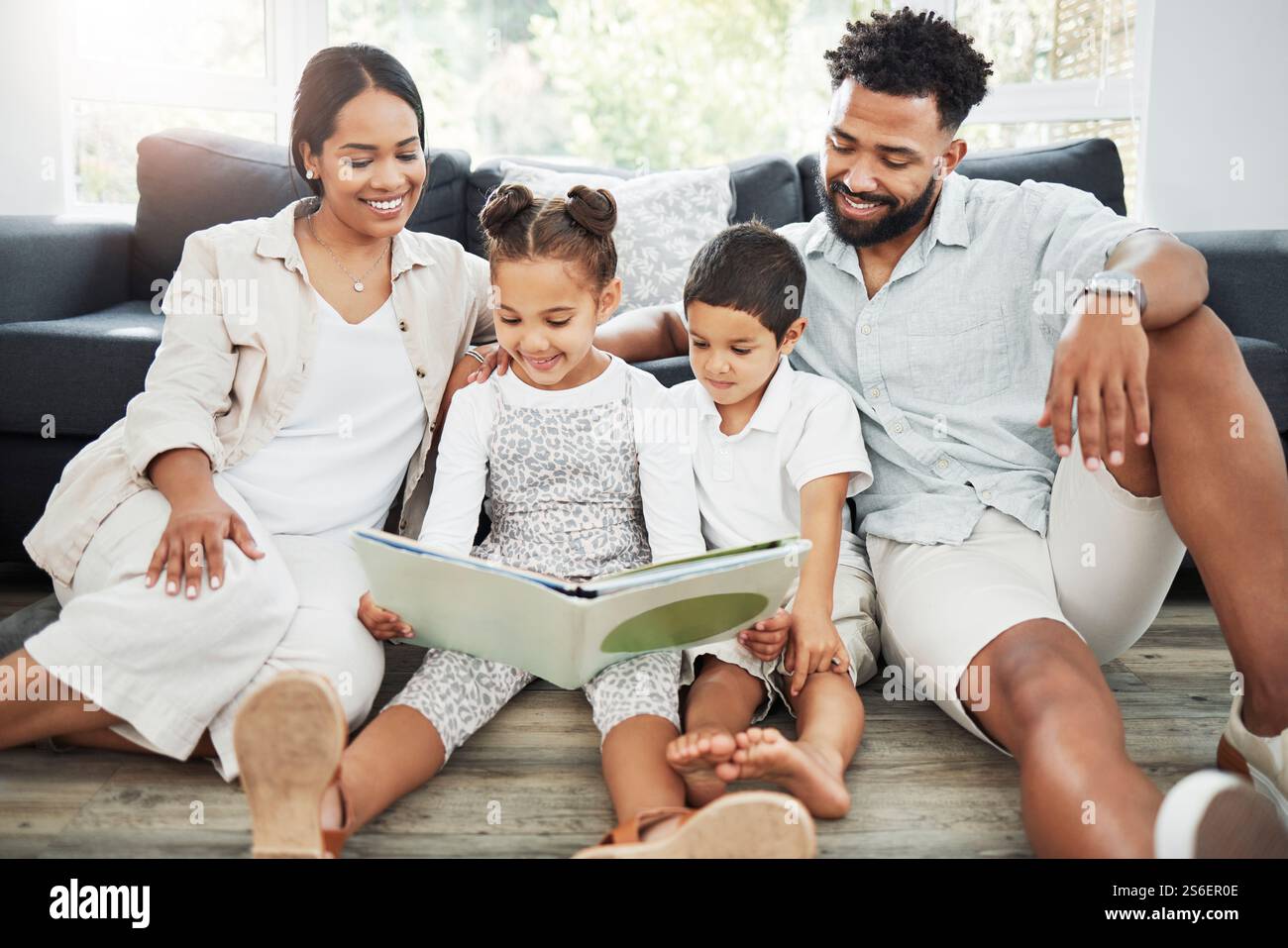 Familie, Kinder und Lesebücher zu Hause, Liebe und Unterstützung mit englischunterricht auf der Etage der Lounge. Eltern, Kinder und Betreuung der Lernentwicklung Stockfoto