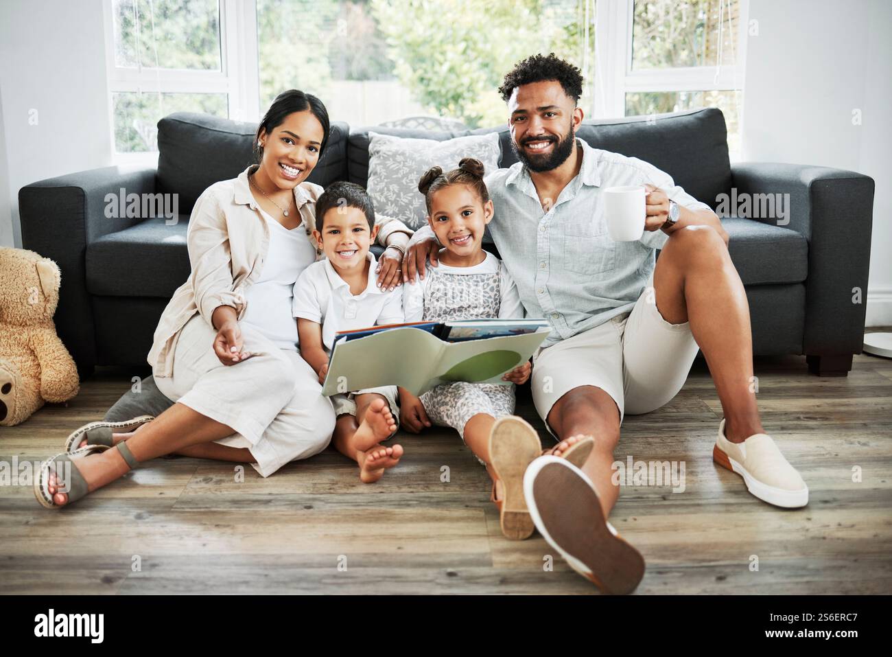 Familie, Kinder und Lesebuch zu Hause, Porträt und Unterstützung mit englischunterricht auf der Etage der Lounge. Eltern, Kinder und Fürsorge für das Lernen Stockfoto
