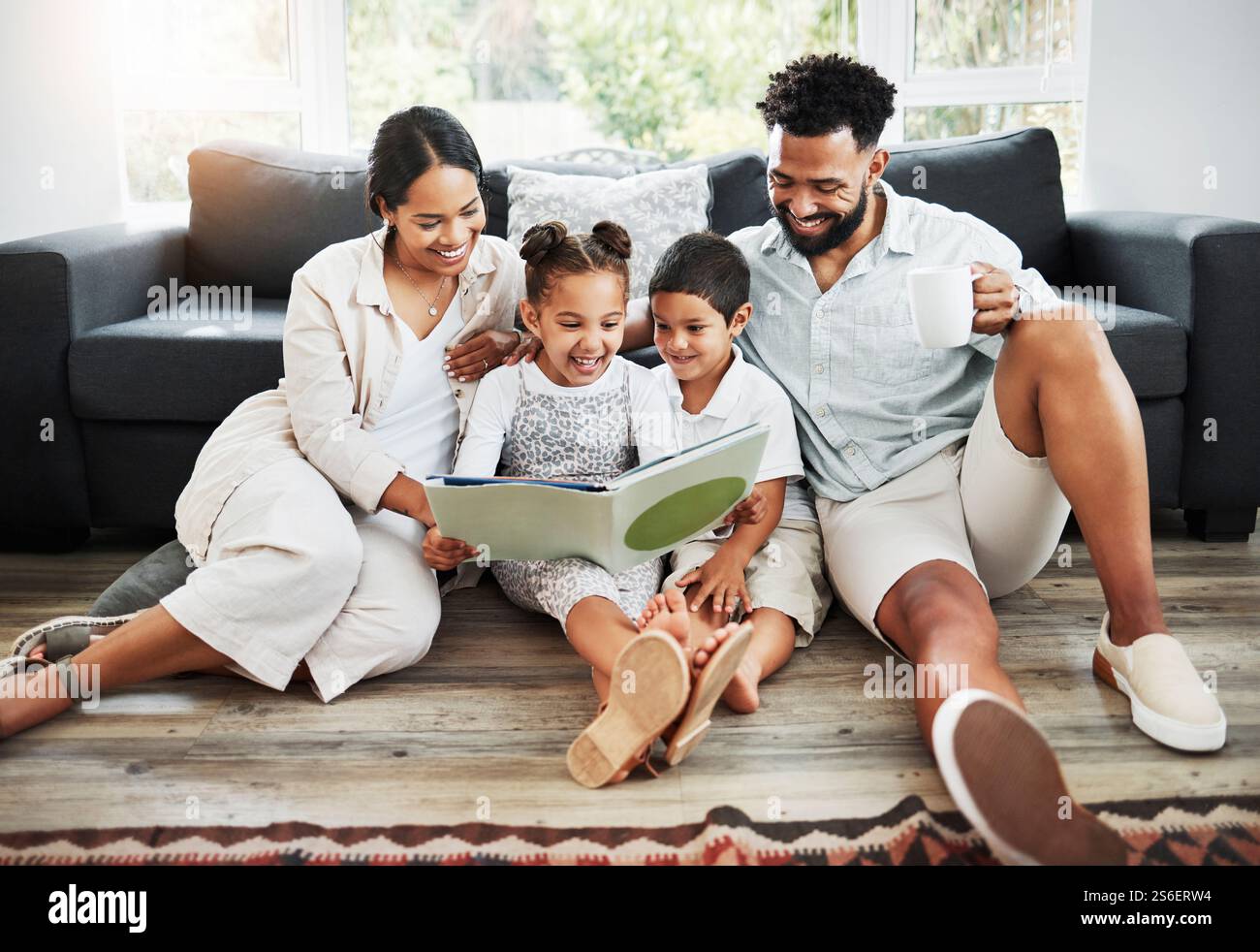 Familie, Kinder und Lesebücher zu Hause, Lese- und Schreibkenntnisse und Unterstützung mit englischunterricht auf der Etage der Lounge. Eltern, Kinder und Liebe zum Lernen Stockfoto