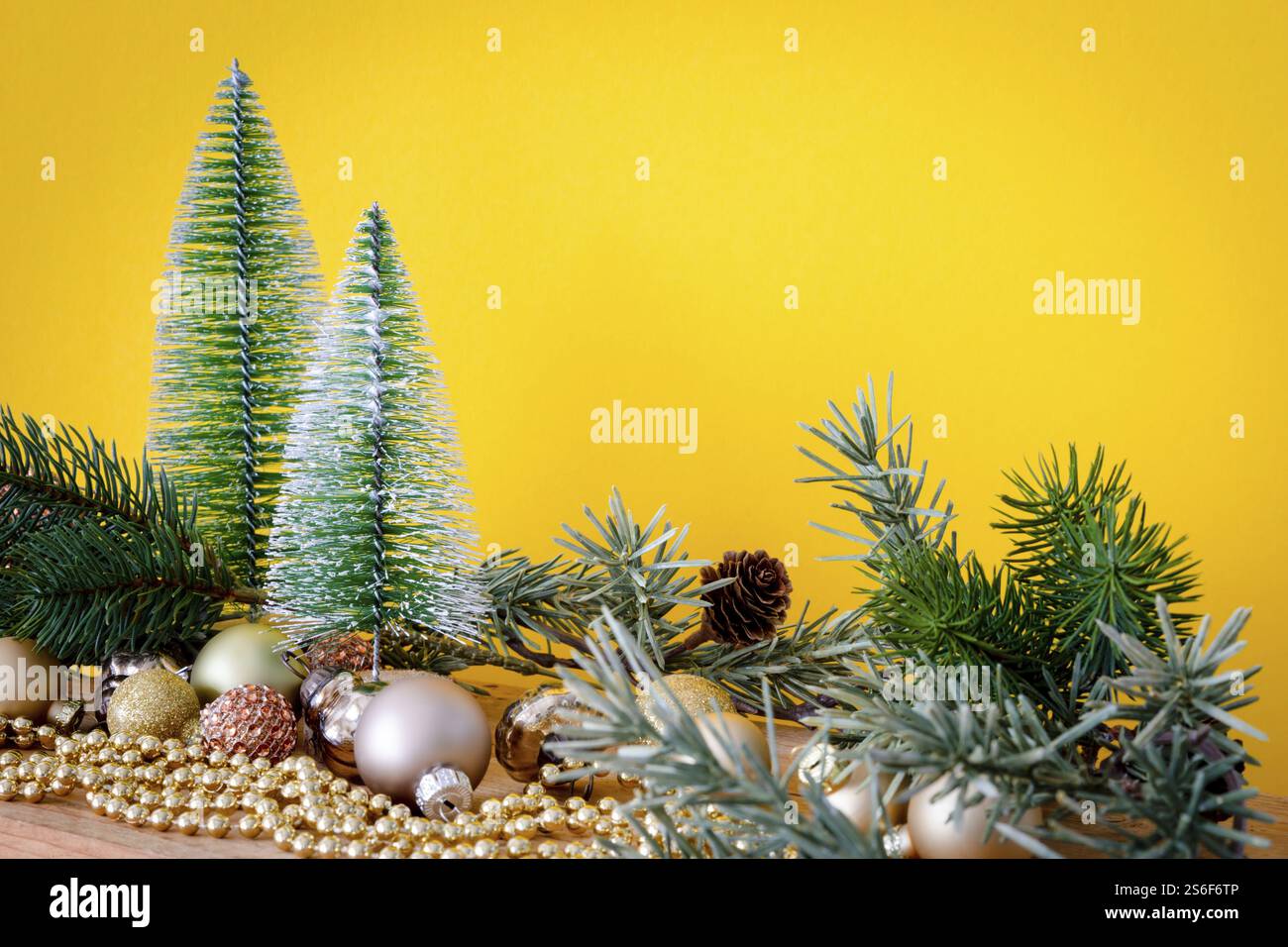 Eine Weihnachtsdekoration Glaskugeln mit Tannenbäumen auf gelbem Hintergrund Stockfoto