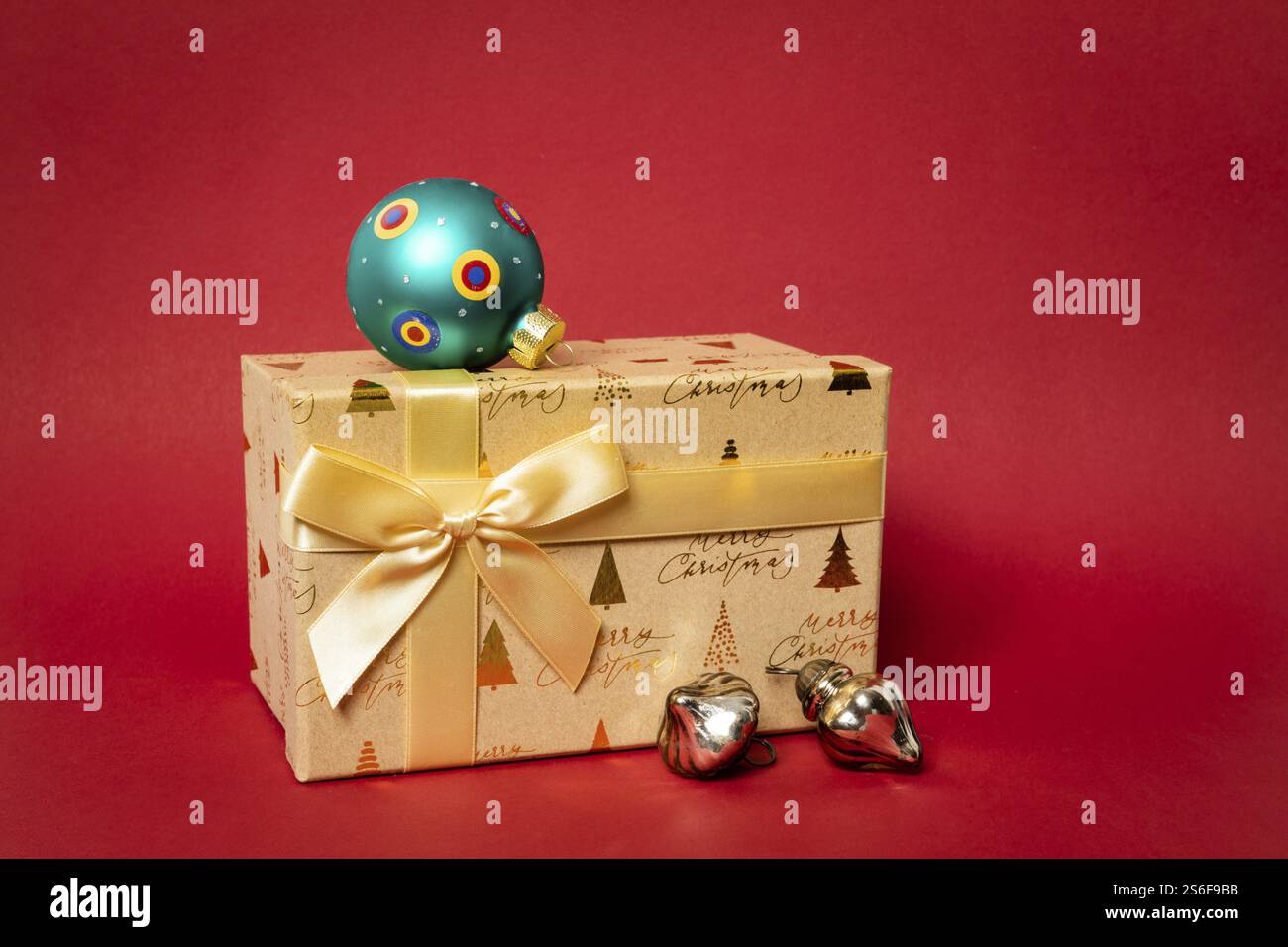 Eine goldene Weihnachts-Geschenkbox auf rotem Hintergrund Stockfoto