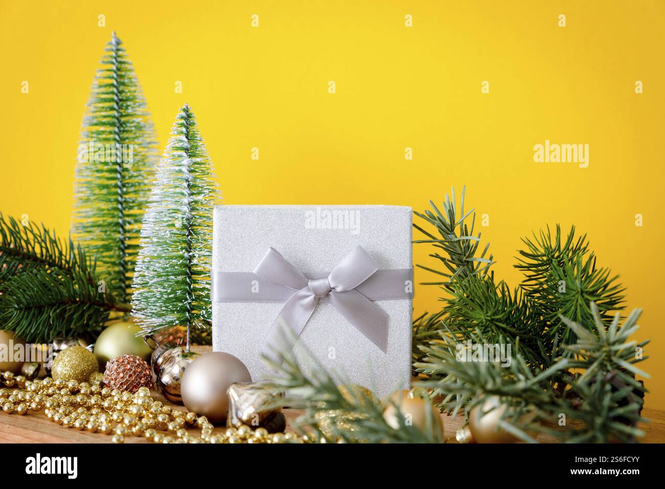 Eine Weihnachtsdekoration Glaskugeln mit Tannenbäumen auf gelbem Hintergrund Stockfoto