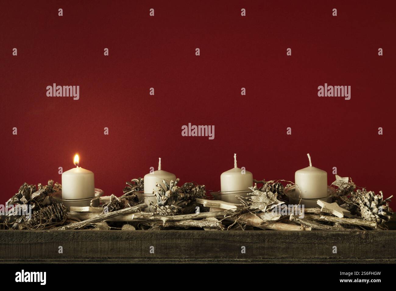 Advent eine Kerzen brennen mit rotem Hintergrund für Ihre Inhalte Stockfoto