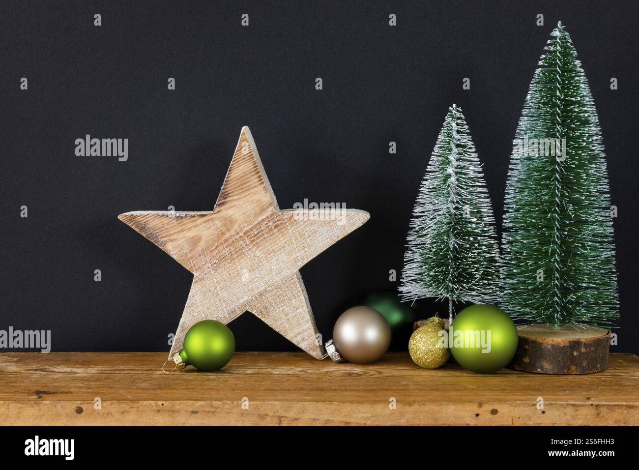 Ein schwarzer Hintergrund mit Weihnachtsdekoration mit Baumglaskugeln und Stern Stockfoto