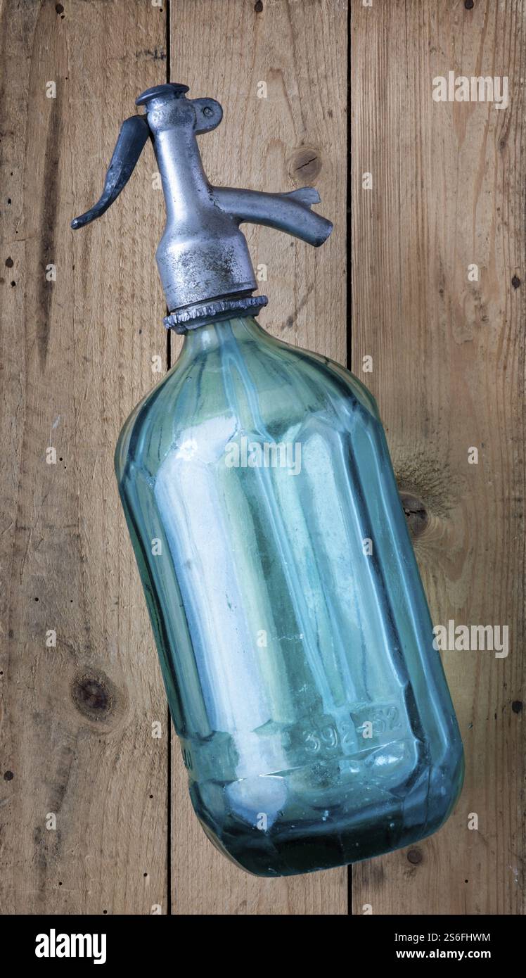 Eine alte türkisfarbene Limonade-Glasflasche auf einem Holztisch Stockfoto