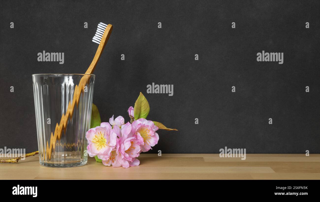Ein Bild einer hölzernen Zahnbürste in einem Glas auf schwarzem Hintergrund Stockfoto
