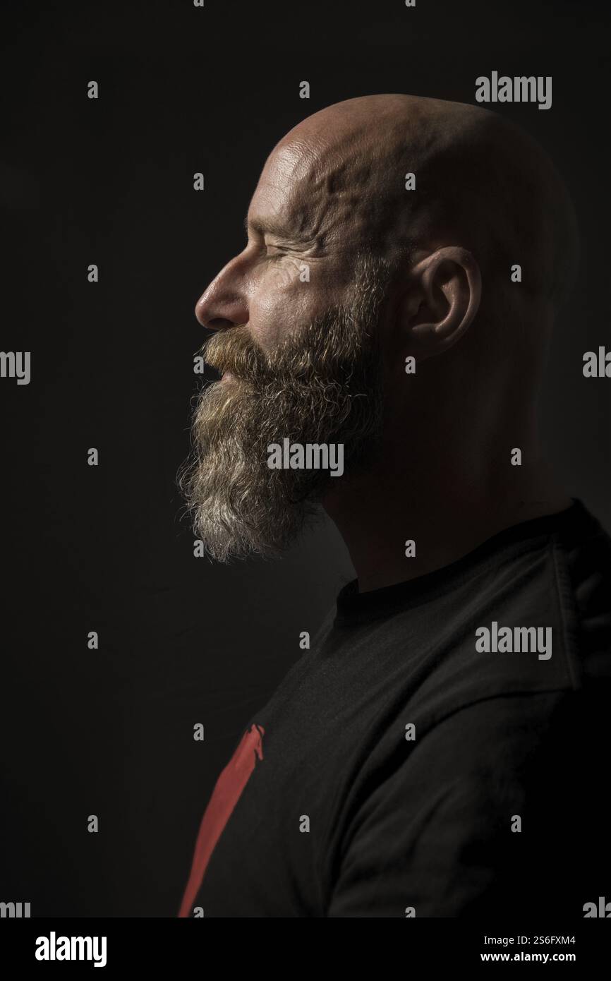 Das Bild eines bärtigen Mannes mit geschlossenen Augen Seitenansicht und dunklen Hintergrund Stockfoto