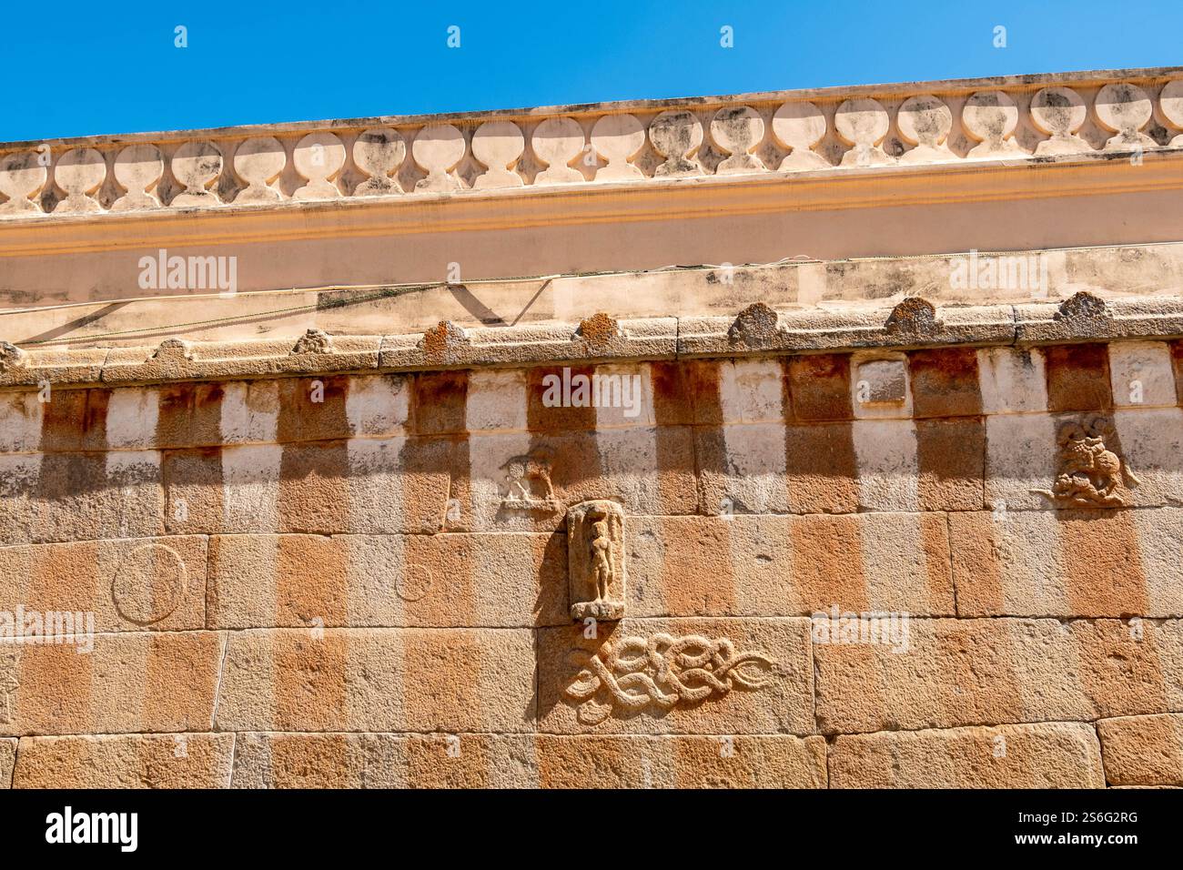 Die gestreifte Steinmauer des alten Jain-Tempels auf dem Vindhyagiri-Hügel in Shravanabelagola. Stockfoto