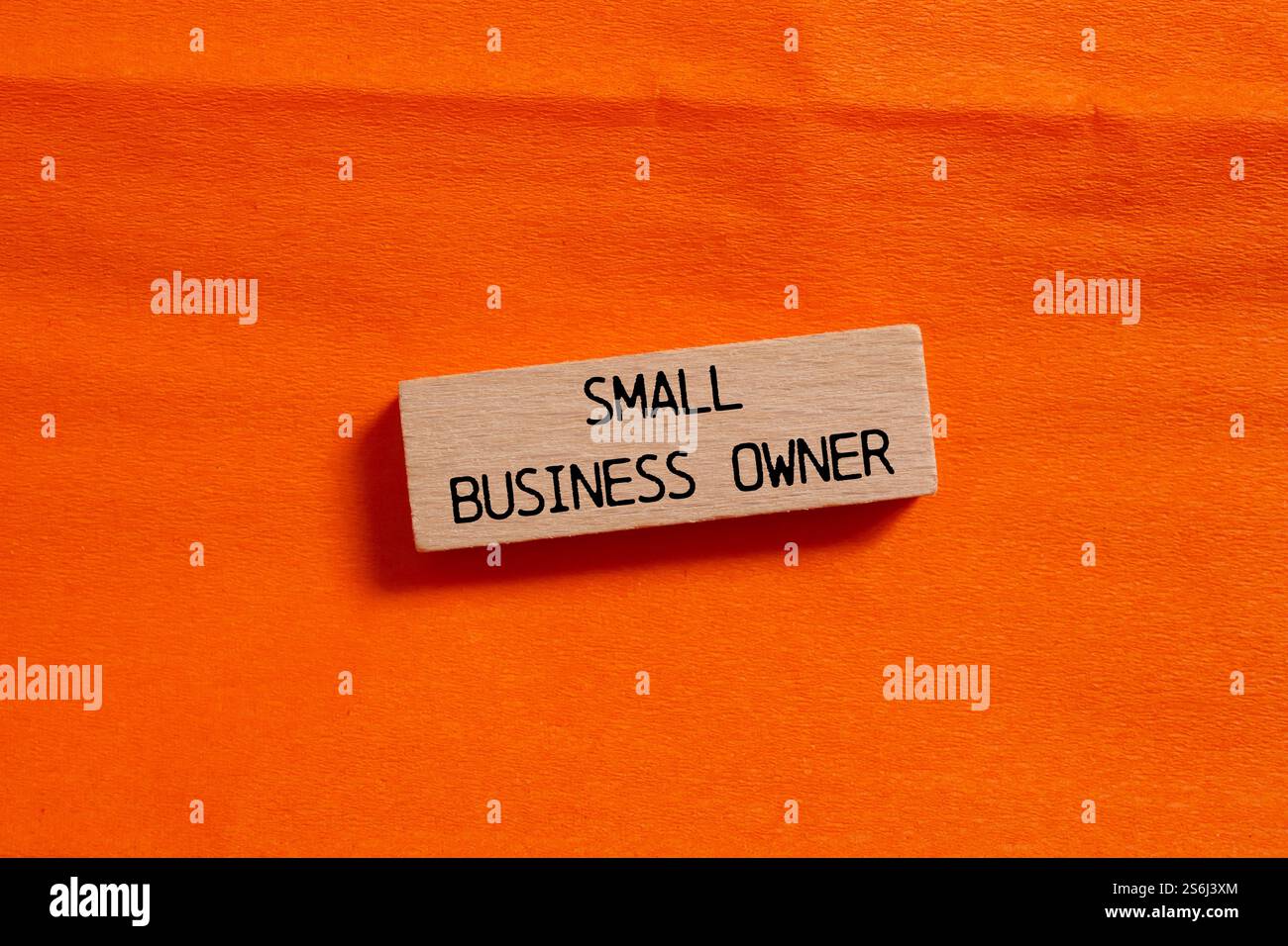 Nachricht des Eigentümers eines kleinen Unternehmens auf einem Holzblock auf orangem Hintergrund. Konzeptionelles Symbol für Inhaber kleiner Unternehmen. Kopierbereich. Stockfoto