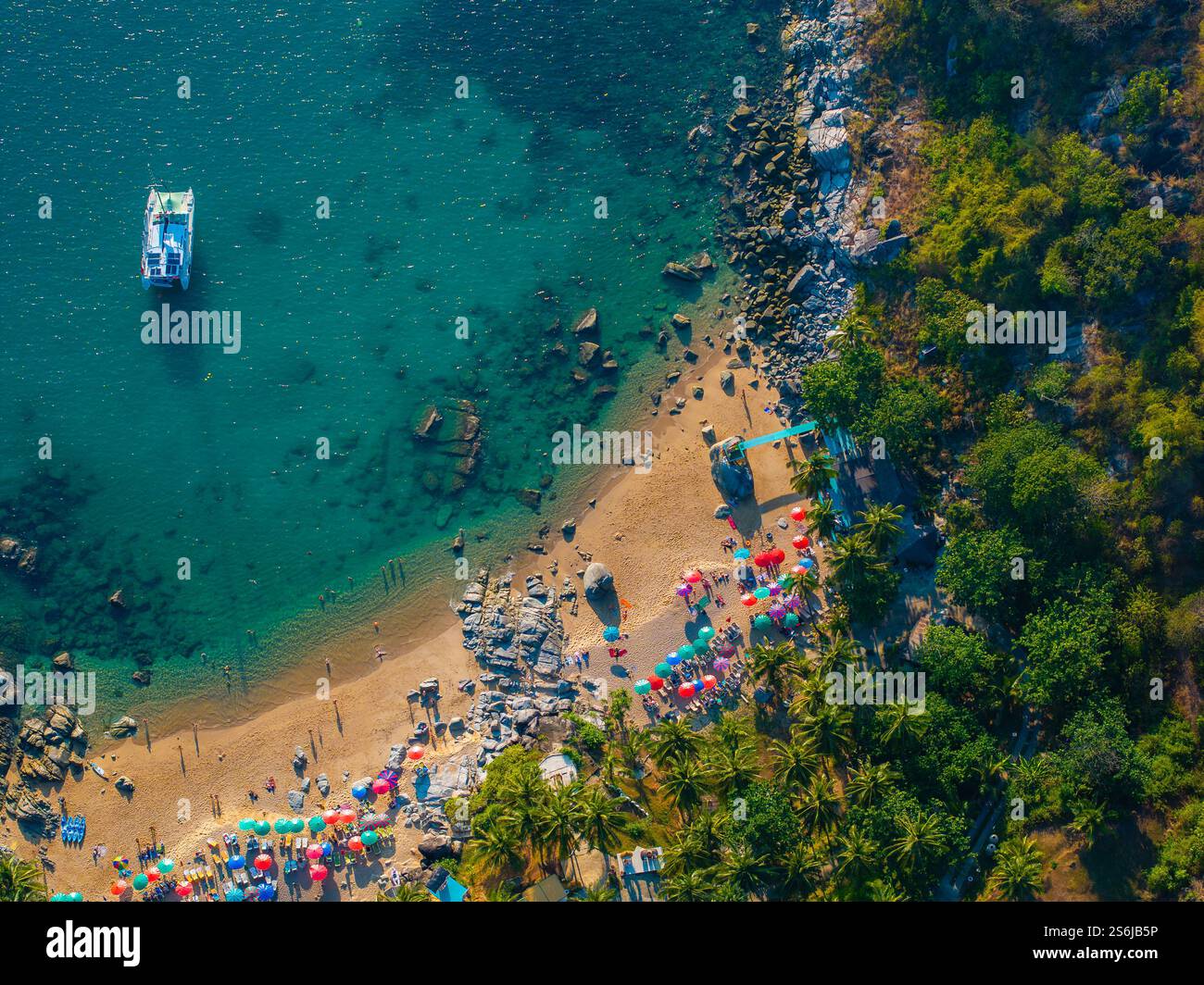 Blick aus der Vogelperspektive auf den lebhaften Strand mit Sonnenschirmen in Phuket, Thailand Stockfoto