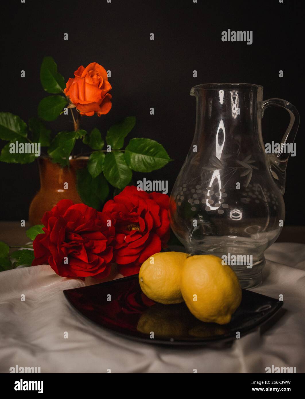 Stillleben auf weißem Tuch mit roten Rosen. Hochwertige Fotos Stockfoto