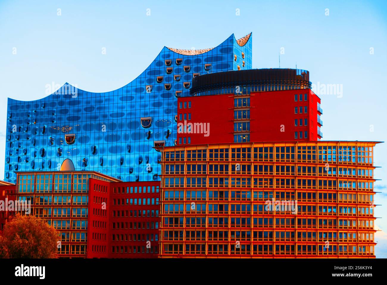 Die Hamburger Elbphilharmonie mit ihrer markanten Glasfassade krönt die Skyline über modernen Backsteinhäusern. Symbol für architektonische Brillanz, reflektiert es c Stockfoto