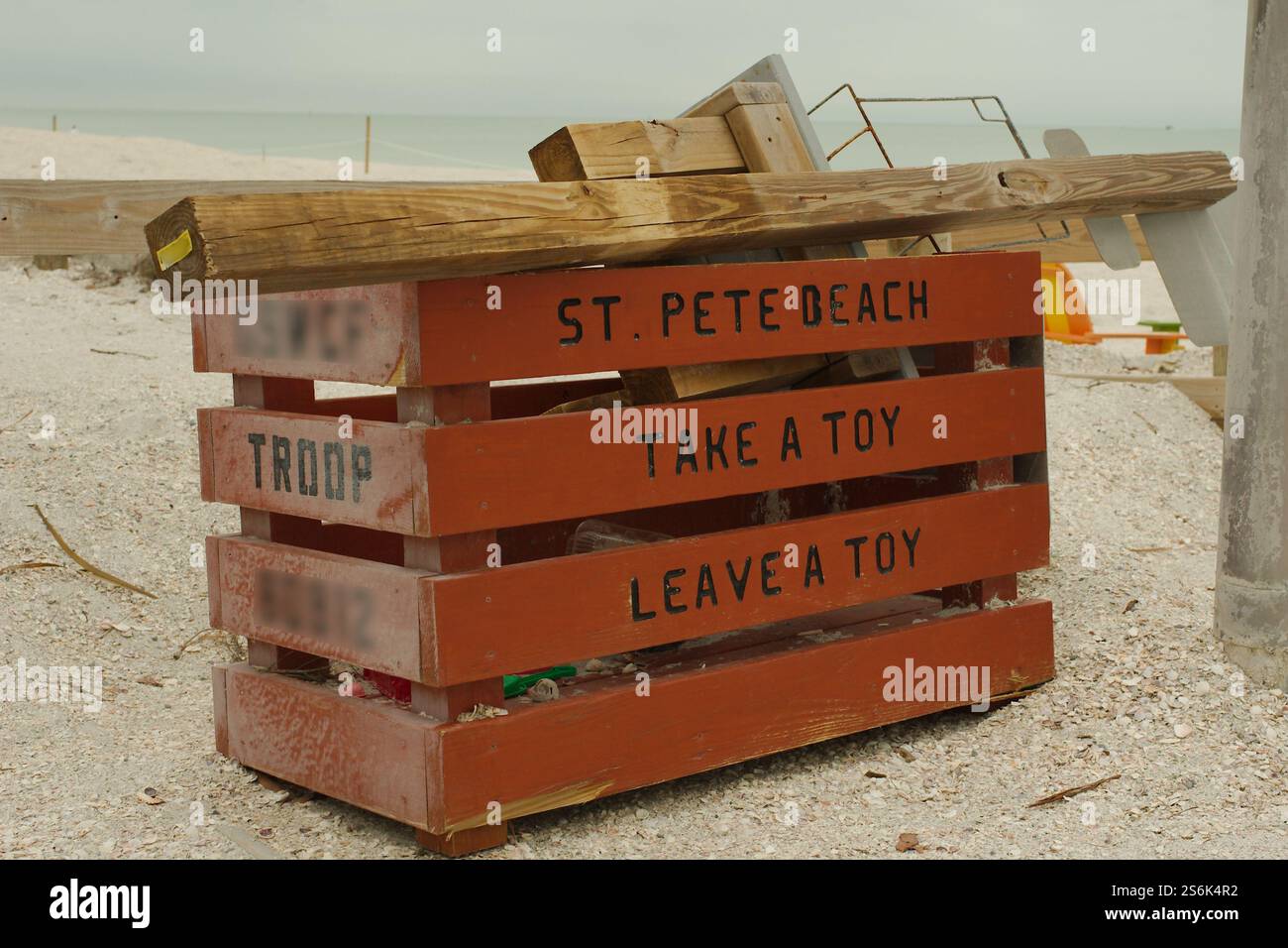 Lassen Sie eine braune Spielzeugkiste am Pass-a-Grille Beach in St. Pete Beach, Florida, liegen. Bewölkter Tag mit Strand im Hintergrund. Kein Zimmer für Personen Stockfoto