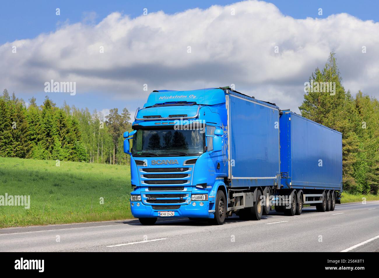 Der blaue Scania R500 Güterwagen zieht an einem sonnigen Sommertag Anhänger auf der Autobahn. Kopierbereich. Uurainen, Finnland. Juni 2019. Stockfoto