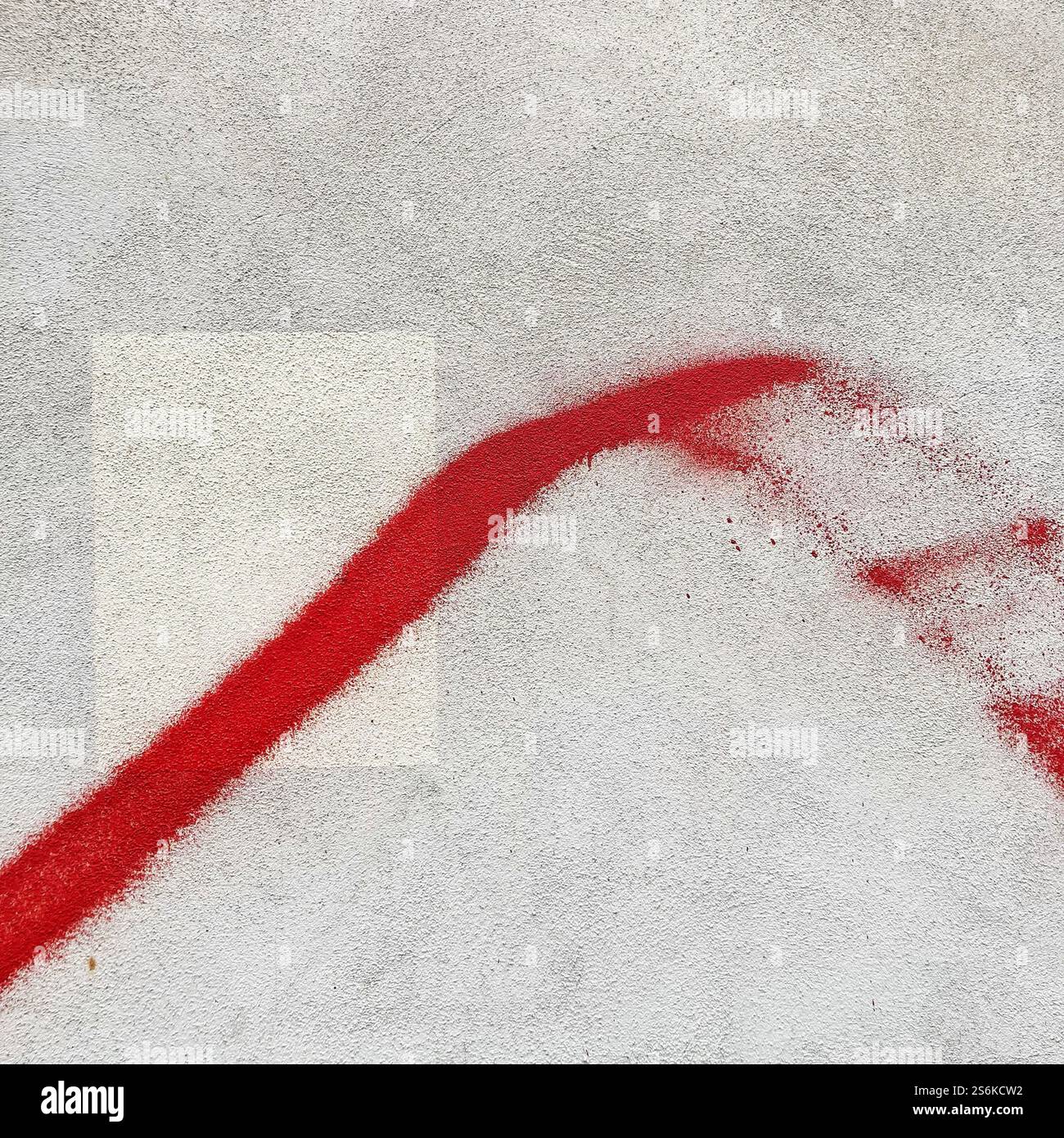 Künstlerisches Bild mit einem kräftigen roten Pinselstrich über einer strukturierten grauen Betonoberfläche, das Minimalismus und Abstraktion betont. - Smartphone-aufgenommenes Stockfoto