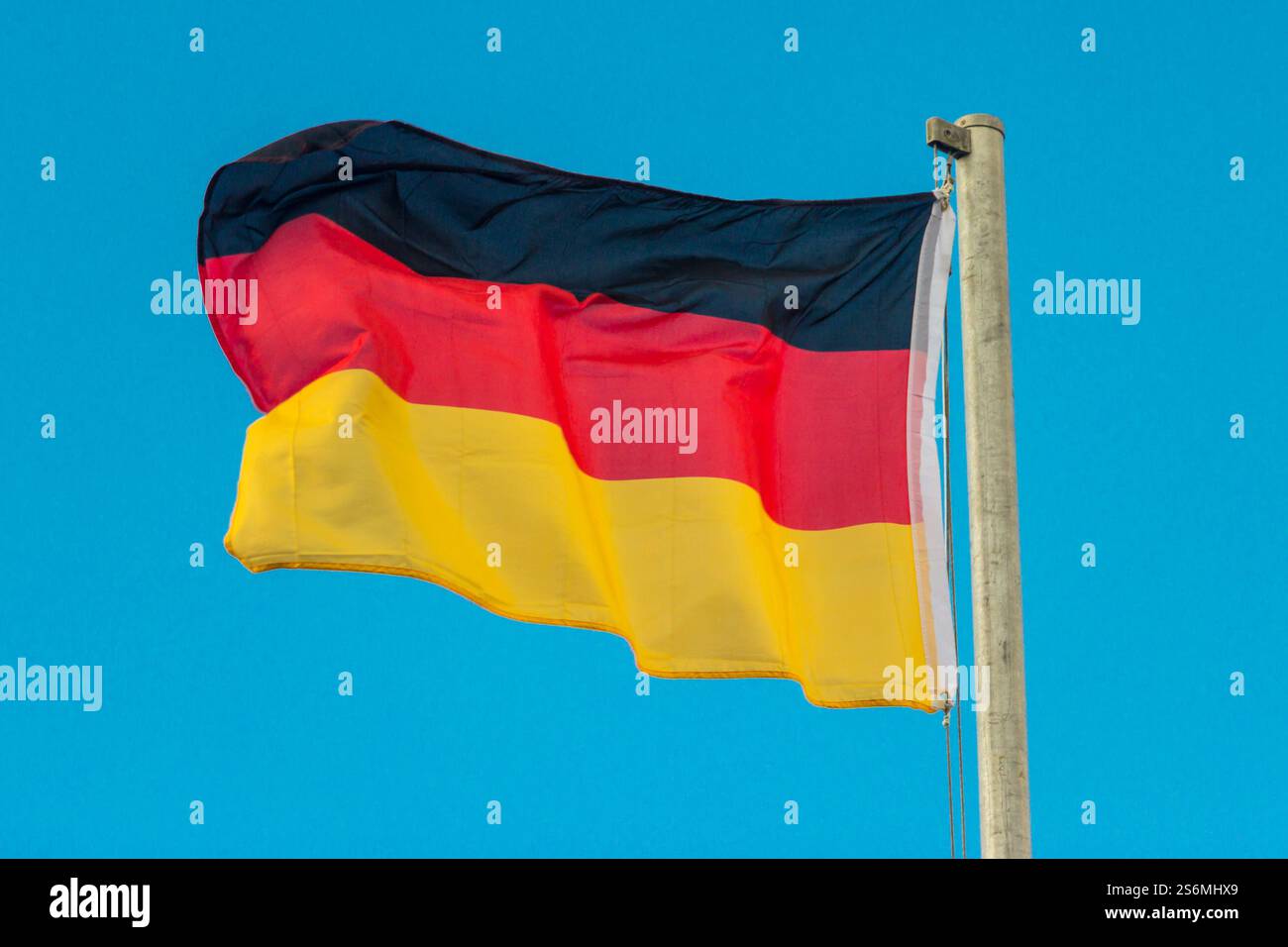 Schwenkende Flagge Deutschlands mit blauem Hintergrund Stockfoto