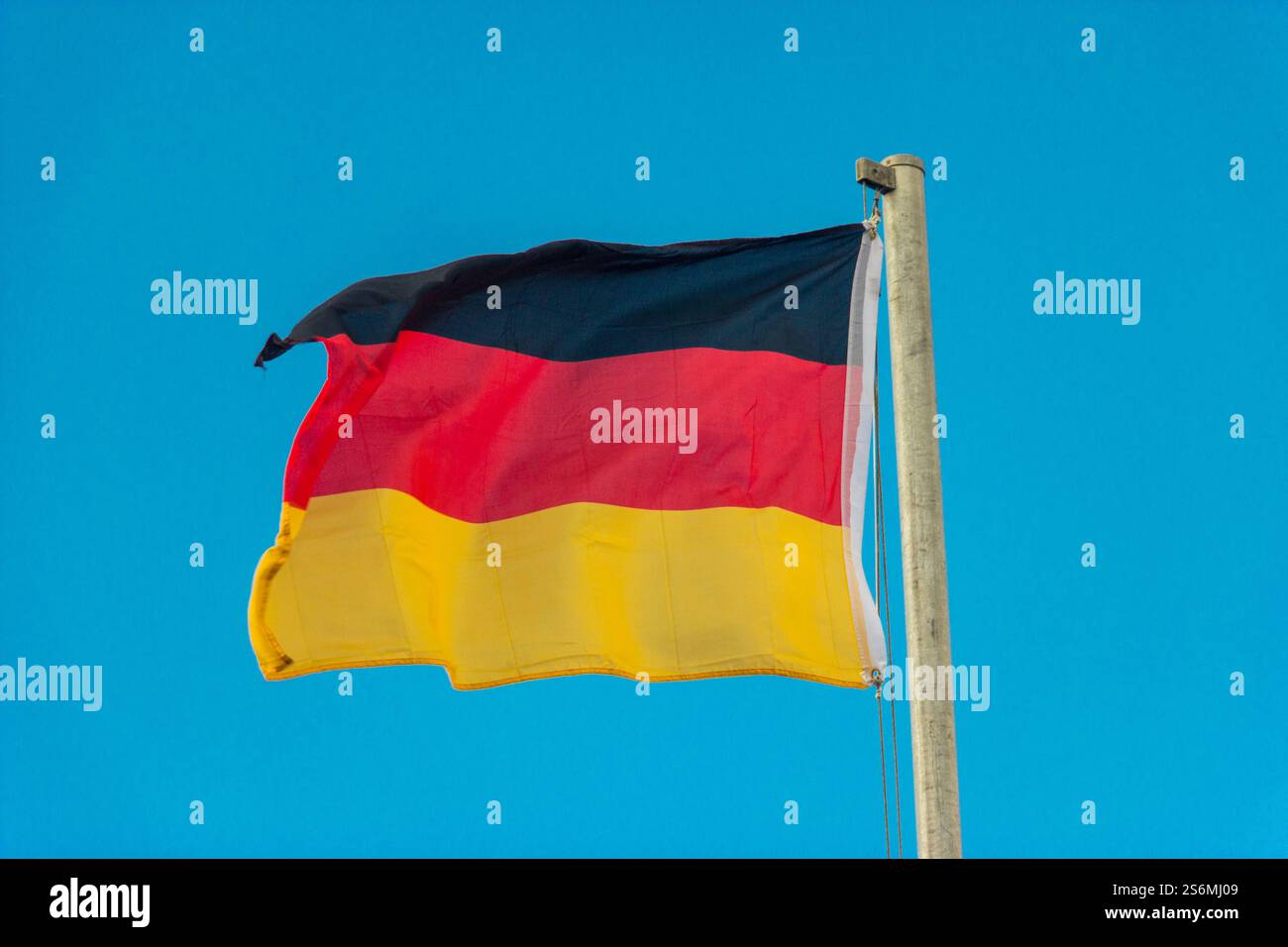 Schwenkende Flagge Deutschlands mit blauem Hintergrund Stockfoto