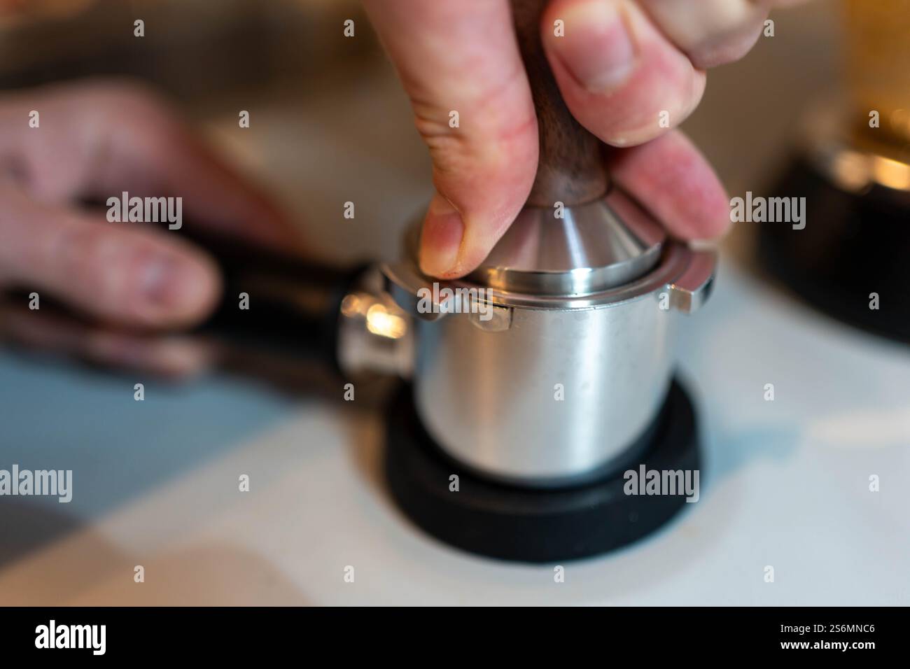 Kaffeezubereitung: Barista Stamping Espresso-Mehl Stockfoto