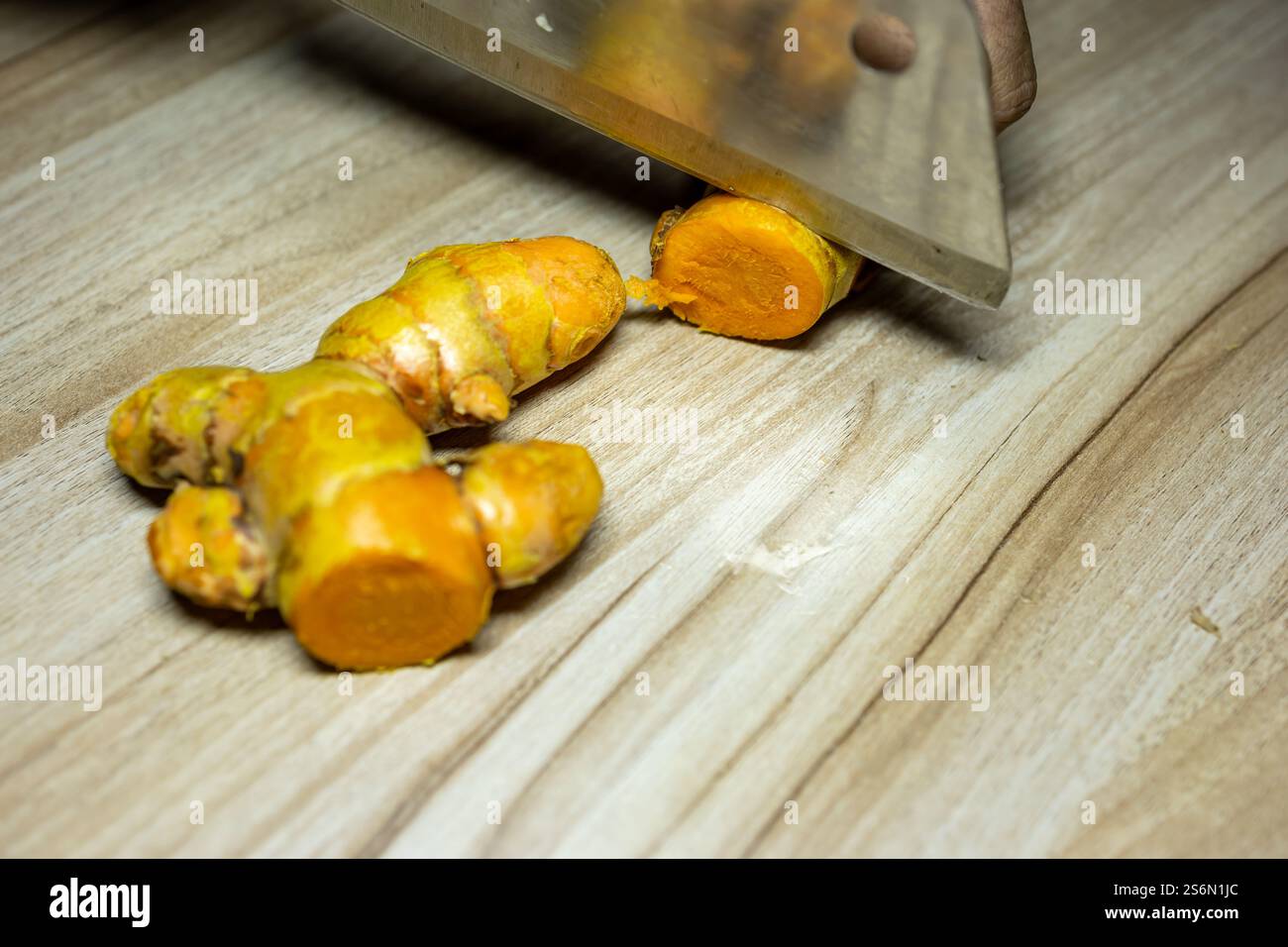 Frische Raw Kurkuma Scheibe mit Messer Nahaufnahme auf Holzbrett Hintergrund Studioaufnahme Stockfoto