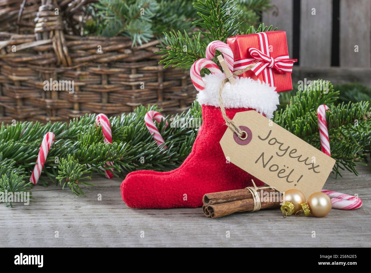 Französische Weihnachtskarte mit roter Weihnachtssocke mit Geschenken und Zuckerstangen Stockfoto