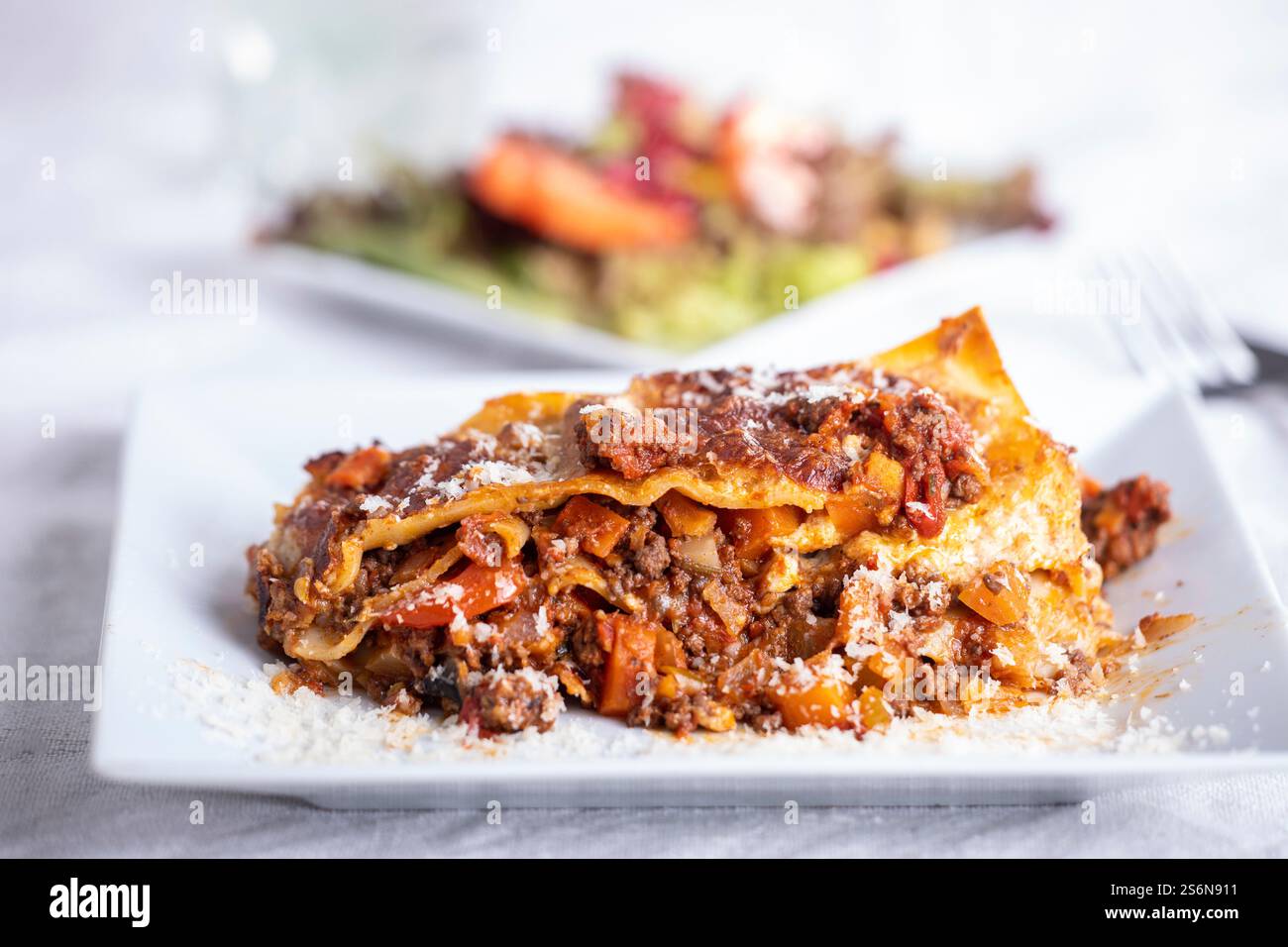 Portion Lasagne auf einem weißen Teller Stockfoto