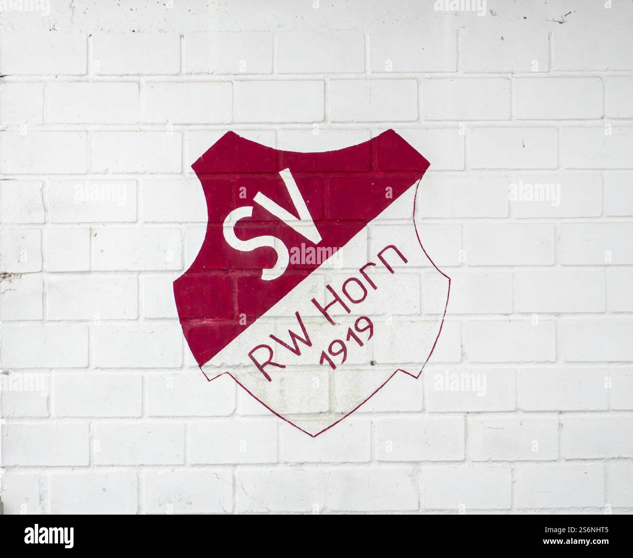 Ein rot-weißes Schild mit den Buchstaben SV RW HORN 1919 ist auf eine weiße Wand gemalt. Das Schild hat einen weißen Hintergrund und ist von Rot umgeben Stockfoto