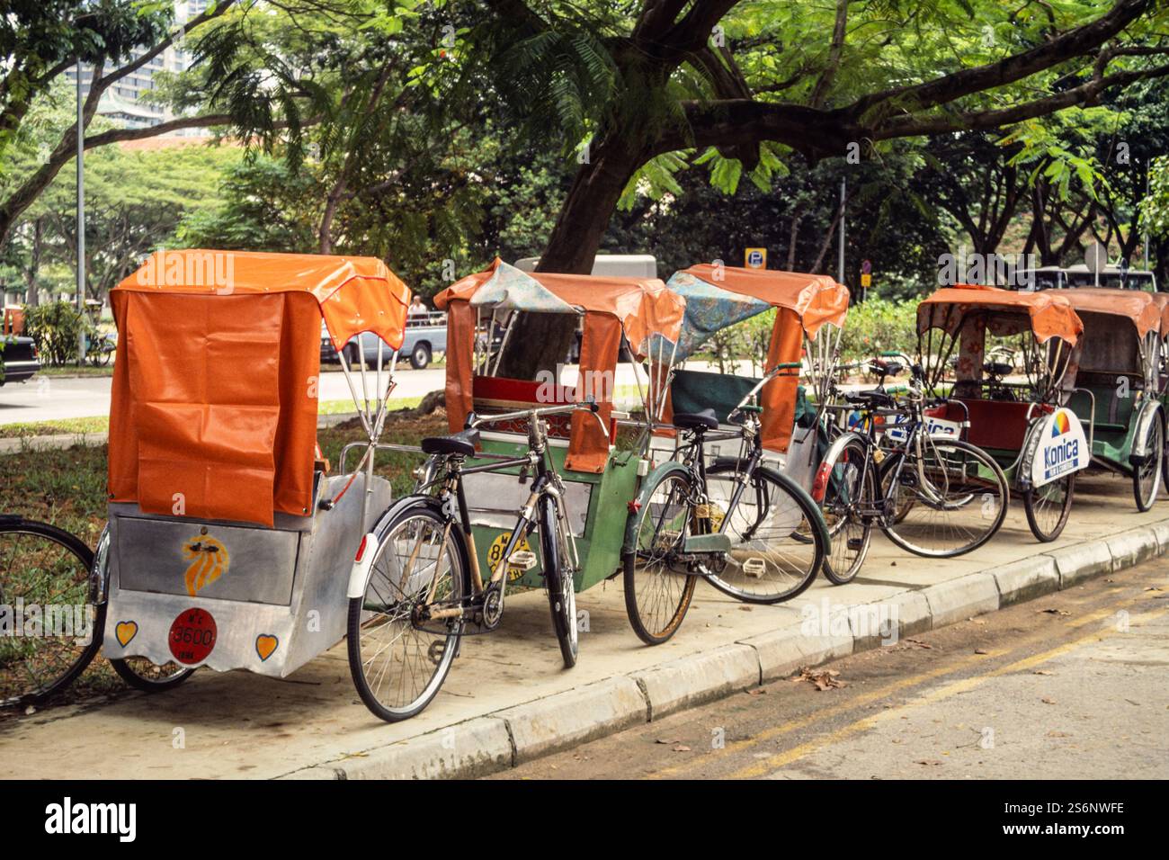 Reihe von Fahrradrikschas oder Pedicabs in Singapur, Asien. Archivfoto aus dem Jahr 1991 Stockfoto