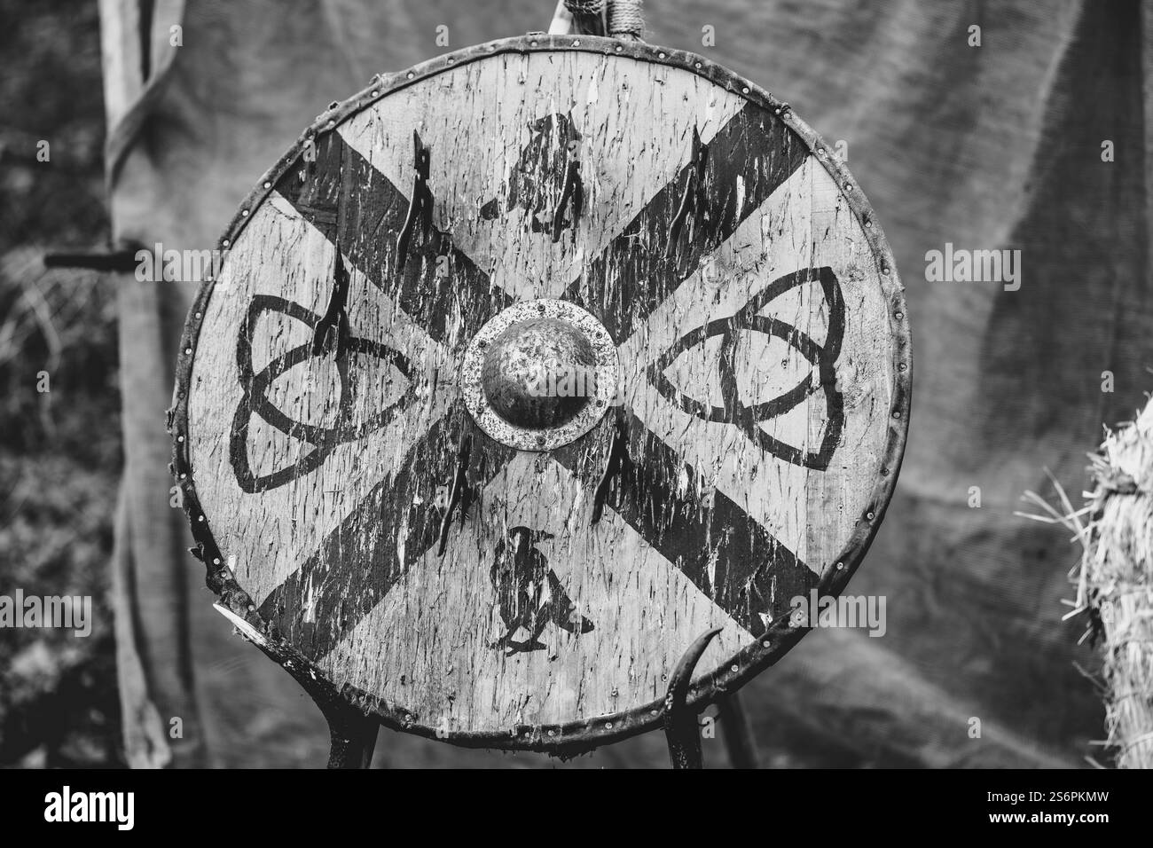 Ein Schwarzweißfoto eines Schildes mit einem keltischen Kreuz darauf. Der Schild ist mit Farbe bedeckt und er ist alt Stockfoto