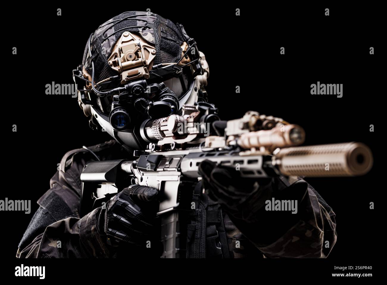 Ein schwer ausgerüsteter Militärsoldat, der ein Gewehr mit High-Tech-Optik anvisiert, taktischen Helm und Ausrüstung trägt, die Bereitschaft und Kampffokus A zeigt Stockfoto