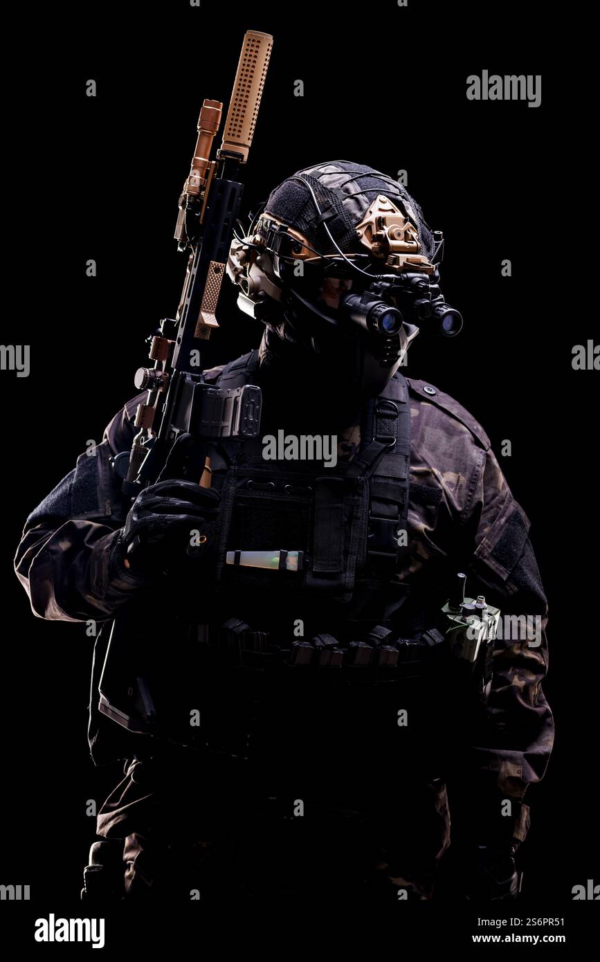 Ein Soldat mit taktischer Ausrüstung und einem Helm mit fortschrittlicher optischer Ausrüstung mit einem Gewehr. Betonung militärischer Professionalität und moderner Ausrüstung Stockfoto