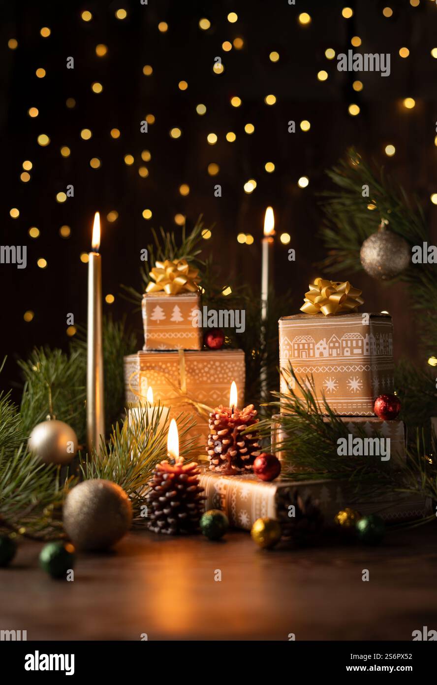 Magische Weihnachtsszene mit beleuchteten Kerzen, dekorierten Geschenken und Tannenzapfen inmitten von leuchtenden Lichtern und festlichen Evergreens für eine gemütliche Weihnachtsatmosphäre Stockfoto