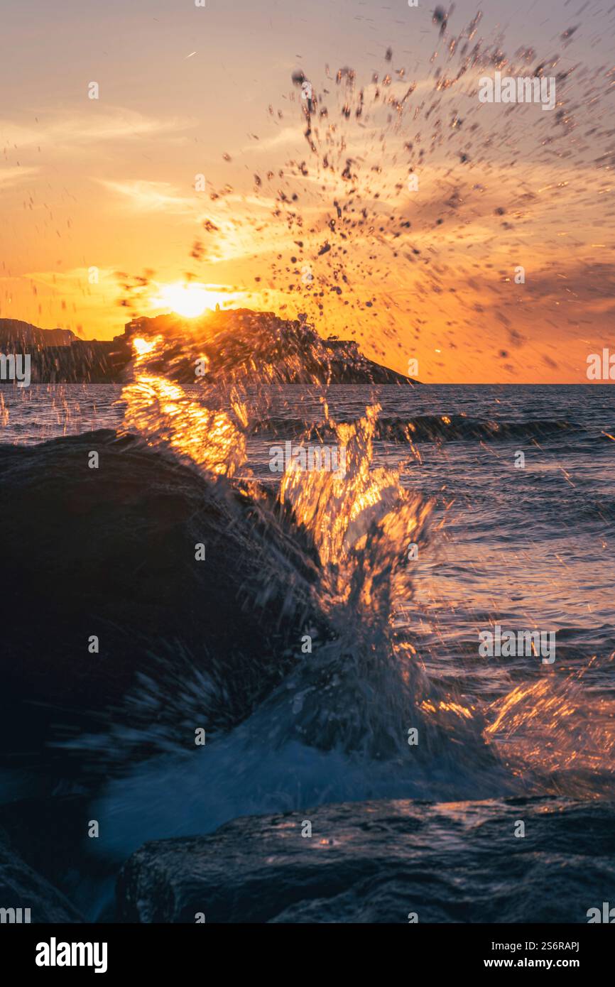 Die Altstadt von Calvi auf der französischen Insel Korsika bei Sonnenuntergang. Die Sonne untergeht hinter der Zitadelle, Meer, Wellen Stockfoto