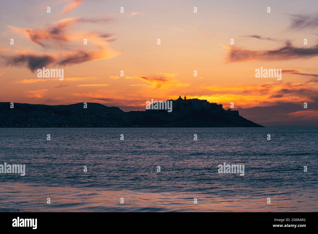 Die Altstadt von Calvi auf der französischen Insel Korsika bei Sonnenuntergang. Die Sonne geht hinter der Zitadelle unter. Stockfoto