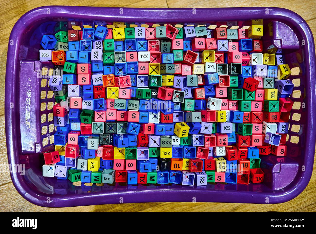 Farbenfrohe Kleidergrößen Plastikwürfel, die auf neuen Kleidungsstücken in Läden zu finden sind Stockfoto