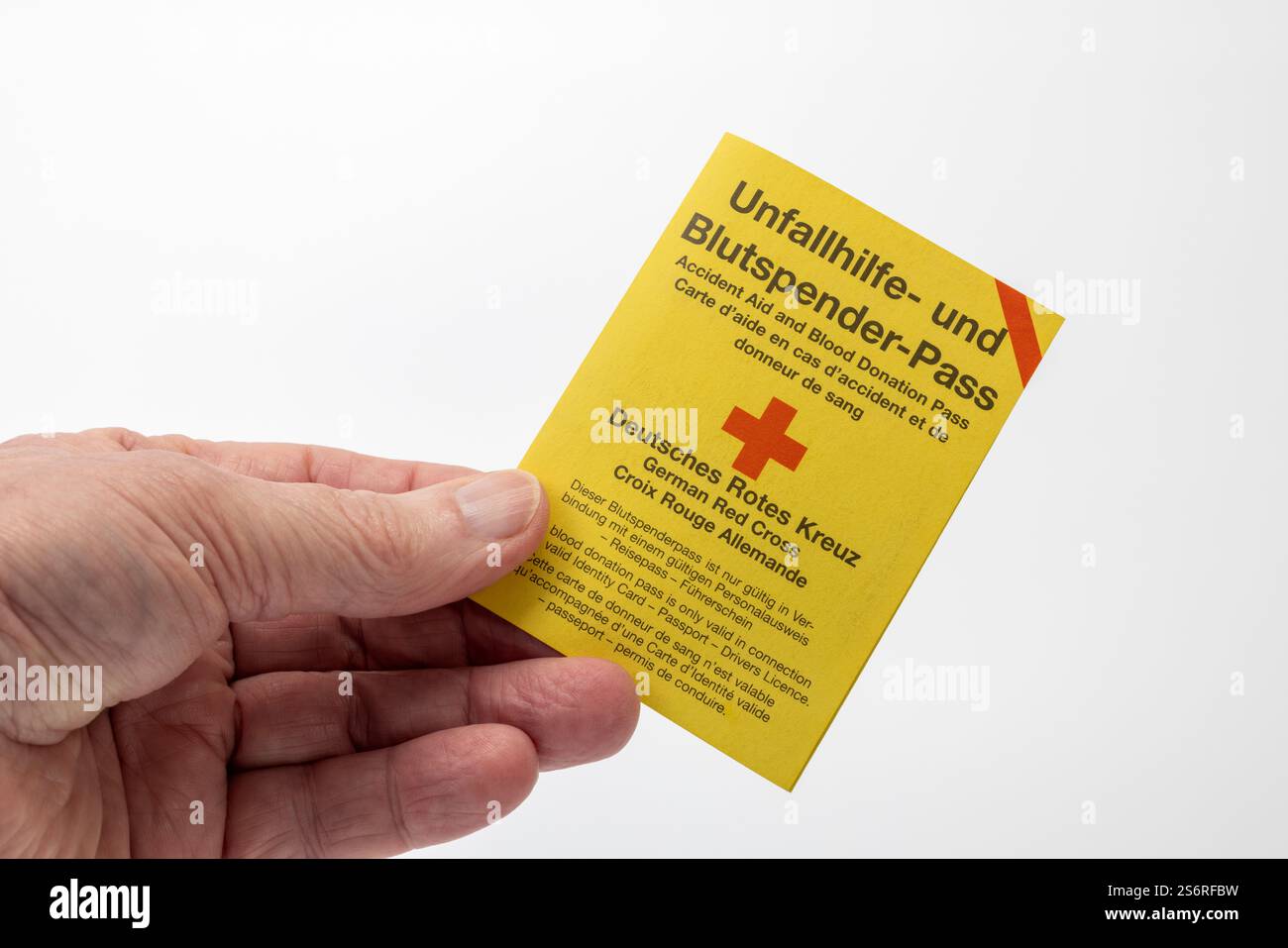 Die Hand des Mannes hält Unfallhilfe und Blutspenderausweis, weißer Hintergrund, Stockfoto