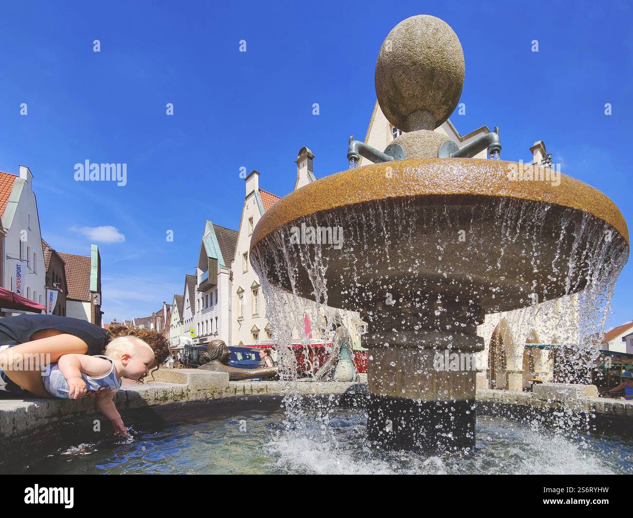 Das Kleinkind wird am Marktbrunnen in Deutschland, Nordrhein-Westfalen, Haltern am See erfrischt Stockfoto