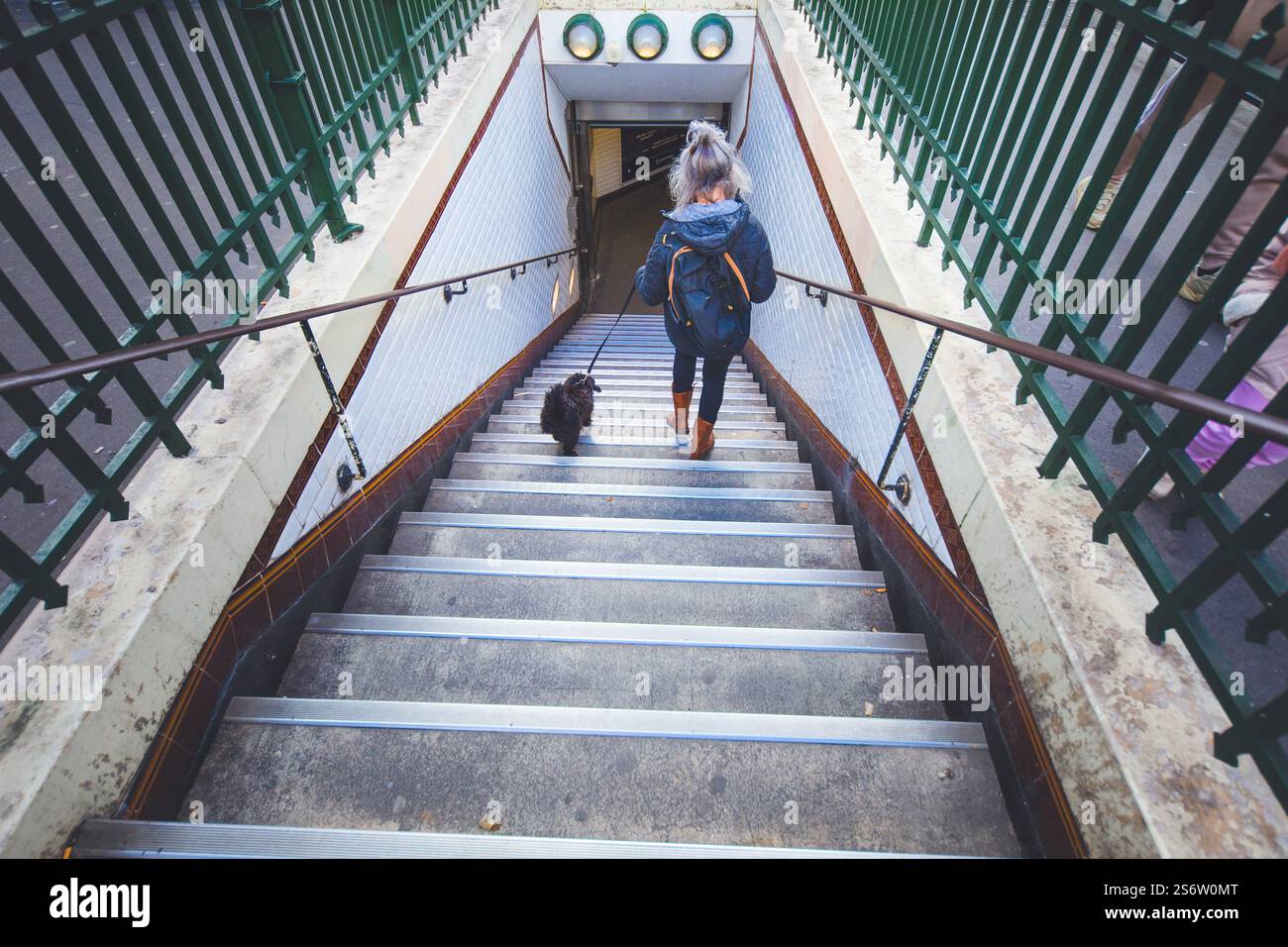 Frankreich, Ile de France, seine-Saint-Denis, Saint-Ouen. Grauhaarige Frau, die mit ihrem Hund aus der Metro steigt. Stockfoto