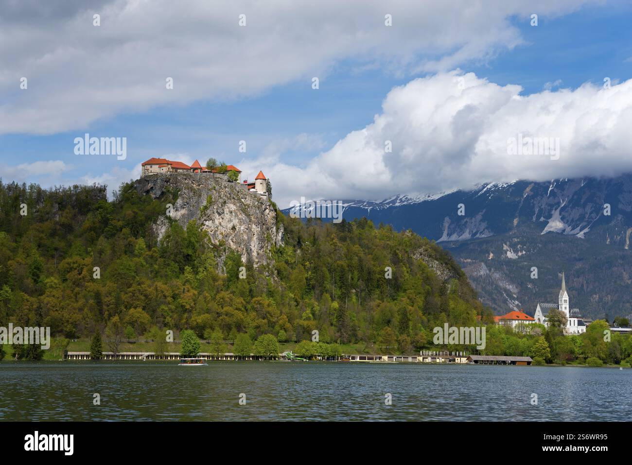 Eine Burg und eine Kirche liegen unter einem bewölkten Himmel in der Nähe eines Sees, des Sees Bled, des Sees Veldes, Blejsko jezero, Bled, Veldes, Feldes, Region Oberkarniola, Gorenjs Stockfoto