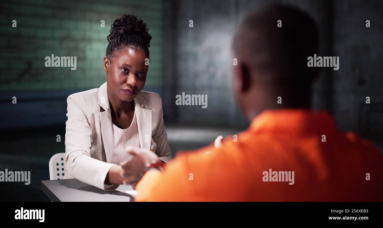 Ein Mann Unterschreibt Ein Schuldbekenntnis Im Gefängnis. Polizeiermittler Im Verhörraum Stockfoto
