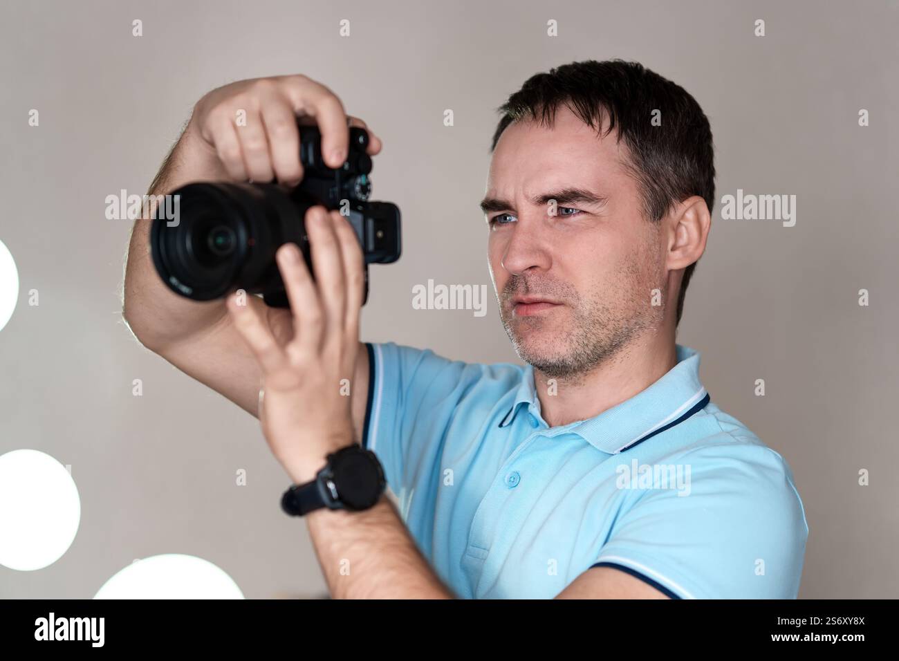 Fotograf Holding spiegellosen Kamera für sein Foto in selektiven Fokus prüfen. paparazzi, der Fotograf Uhren das Motiv durch die Kamera. Ein y Stockfoto