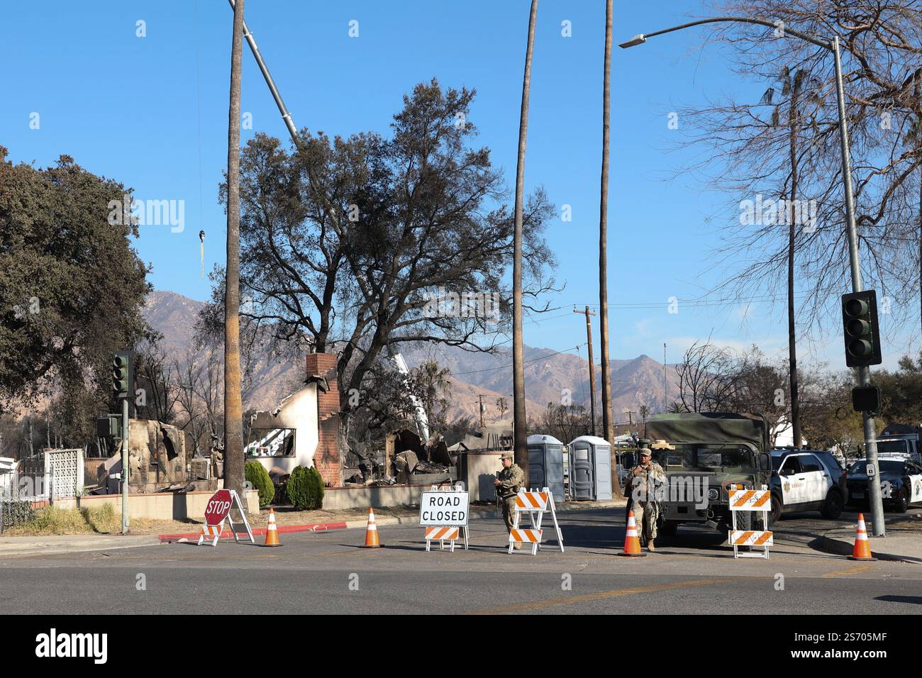 Los Angeles, Usa. Januar 2025. Polizisten und die amerikanische Armee blockieren den Eingang zum Eaton-Wald, wo das Feuer tobt. Katastrophengebiete nördlich der Stadt Pasadena und Altadena nach dem Durchzug des Eaton-Feuers nordöstlich von Los Angeles, der am dienstag, den 7. januar 2025 in Los Angeles begann. Foto: Christophe Michel/ABACAPRESS. COM Credit: Abaca Press/Alamy Live News Stockfoto