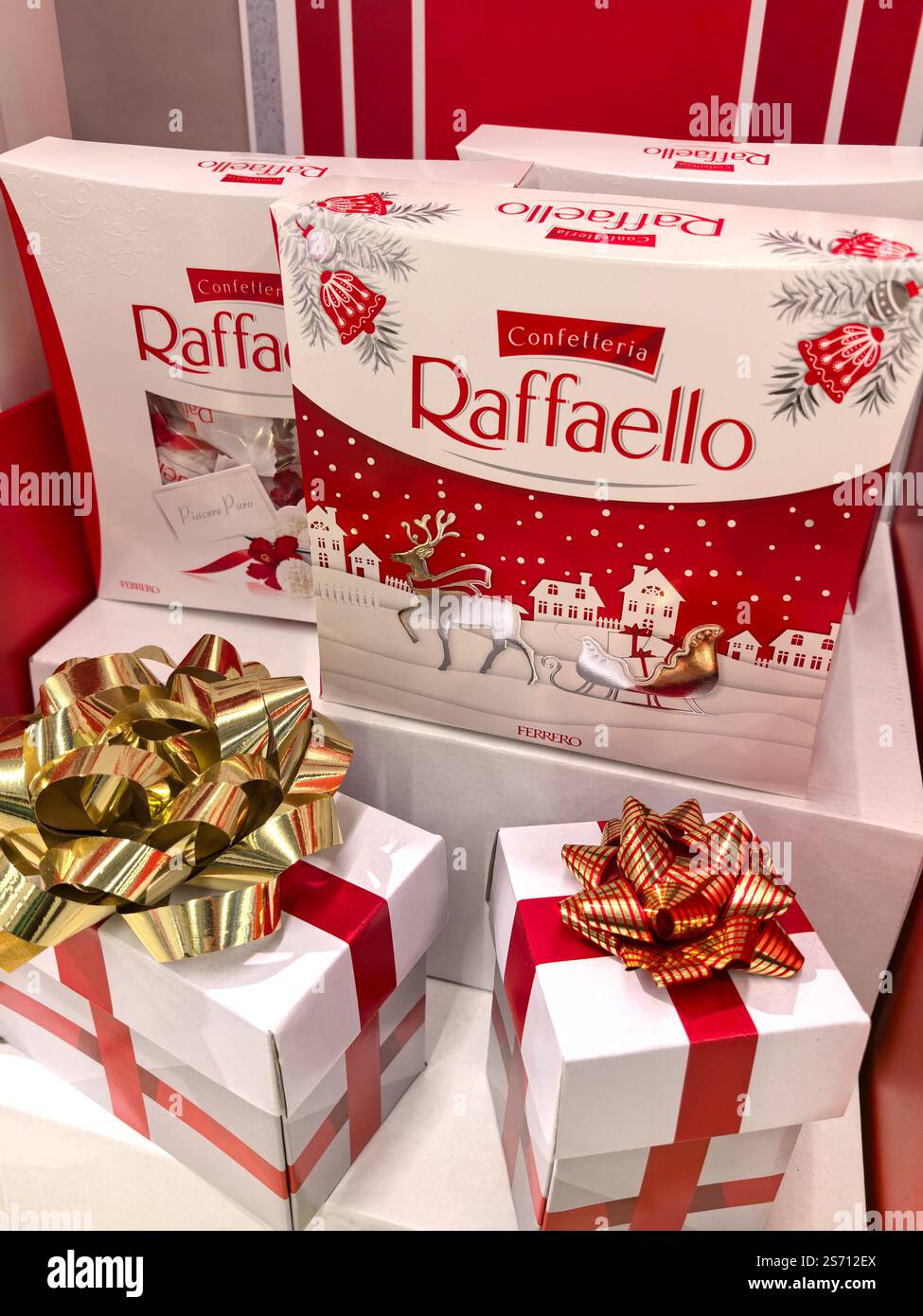 Bobruisk, Weißrussland - 7. Januar 2025: Farbenfrohe Schachteln mit Raffaello-Konfekt sind elegant angeordnet, zusammen mit wunderschön verpackten Geschenken. Stockfoto