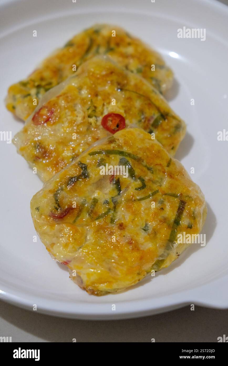 Indonesischer Snack - Martinabak, hergestellt aus Reispapier, Tofu, Ei, Lauch und Chili. Stockfoto