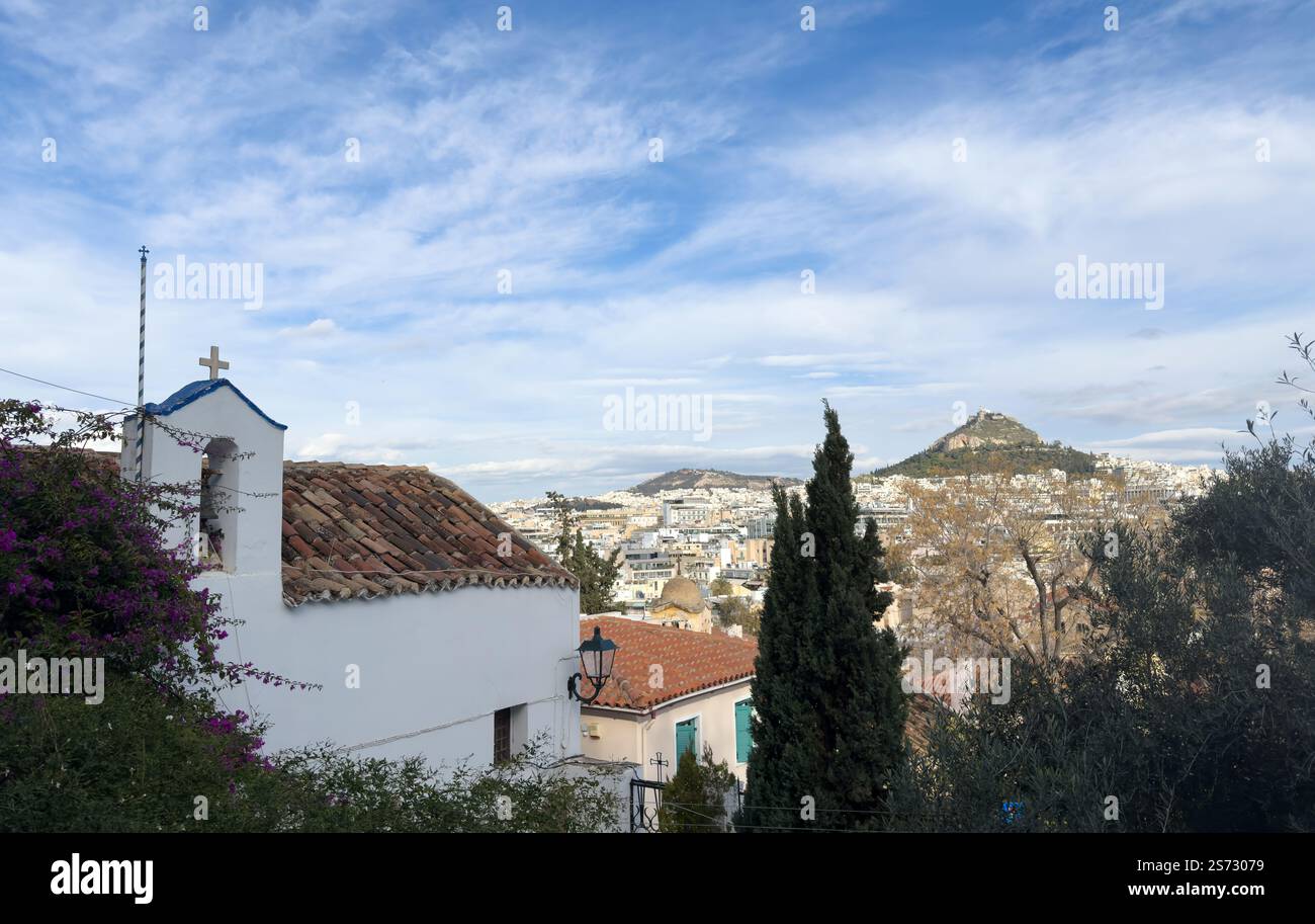 Kleine weiße Kapelle und Stadtbild von Athen mit dem Lycabettus-Berg, Blick vom Akropolis-Hügel in Griechenland, blauer Himmel mit Wolken Stockfoto