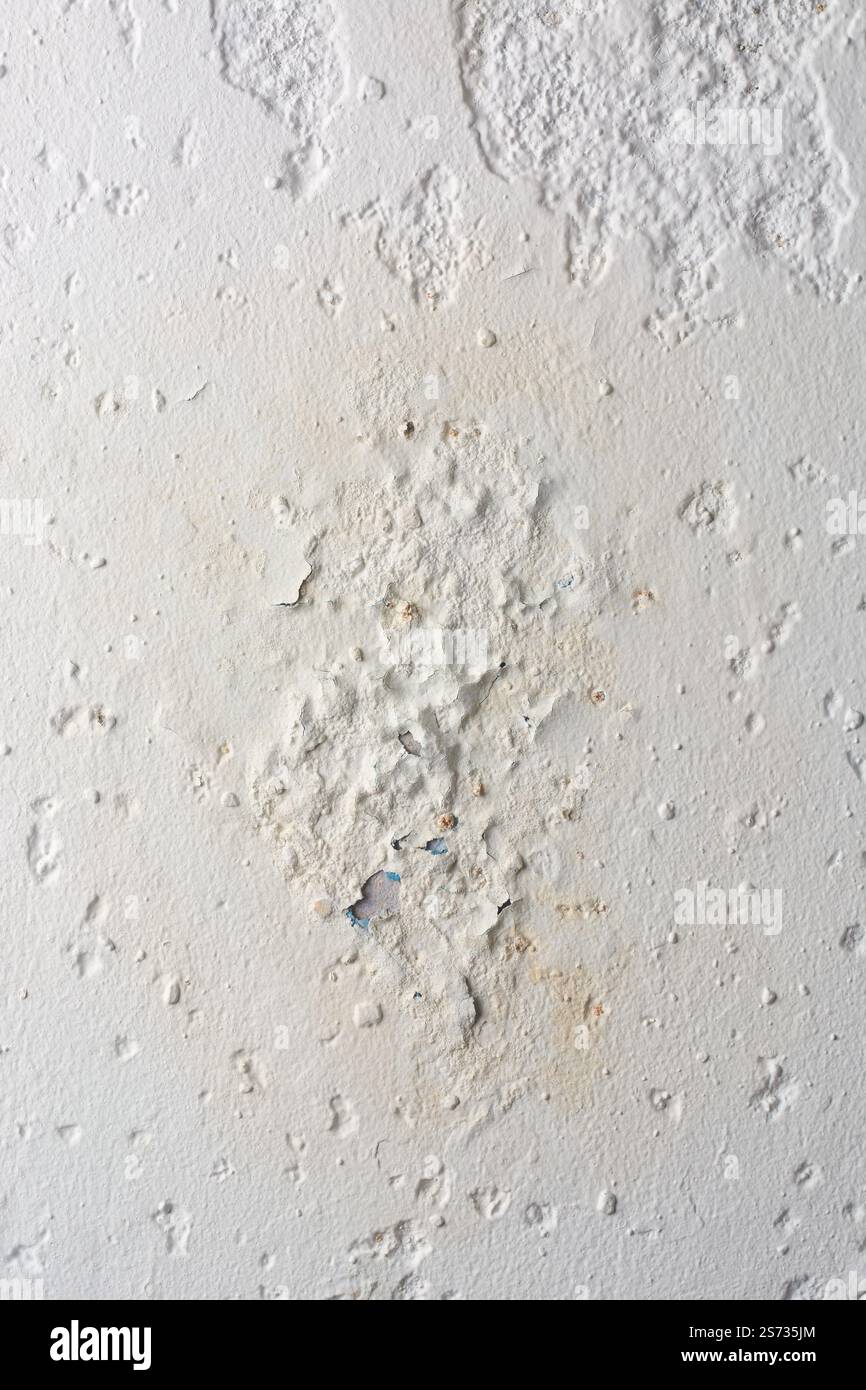 Nahbereich der putzverputzten Wandoberfläche mit Schäden durch Feuchtigkeit, Abblättern oder Abblättern durch Risse, Späne und Wasser Stockfoto