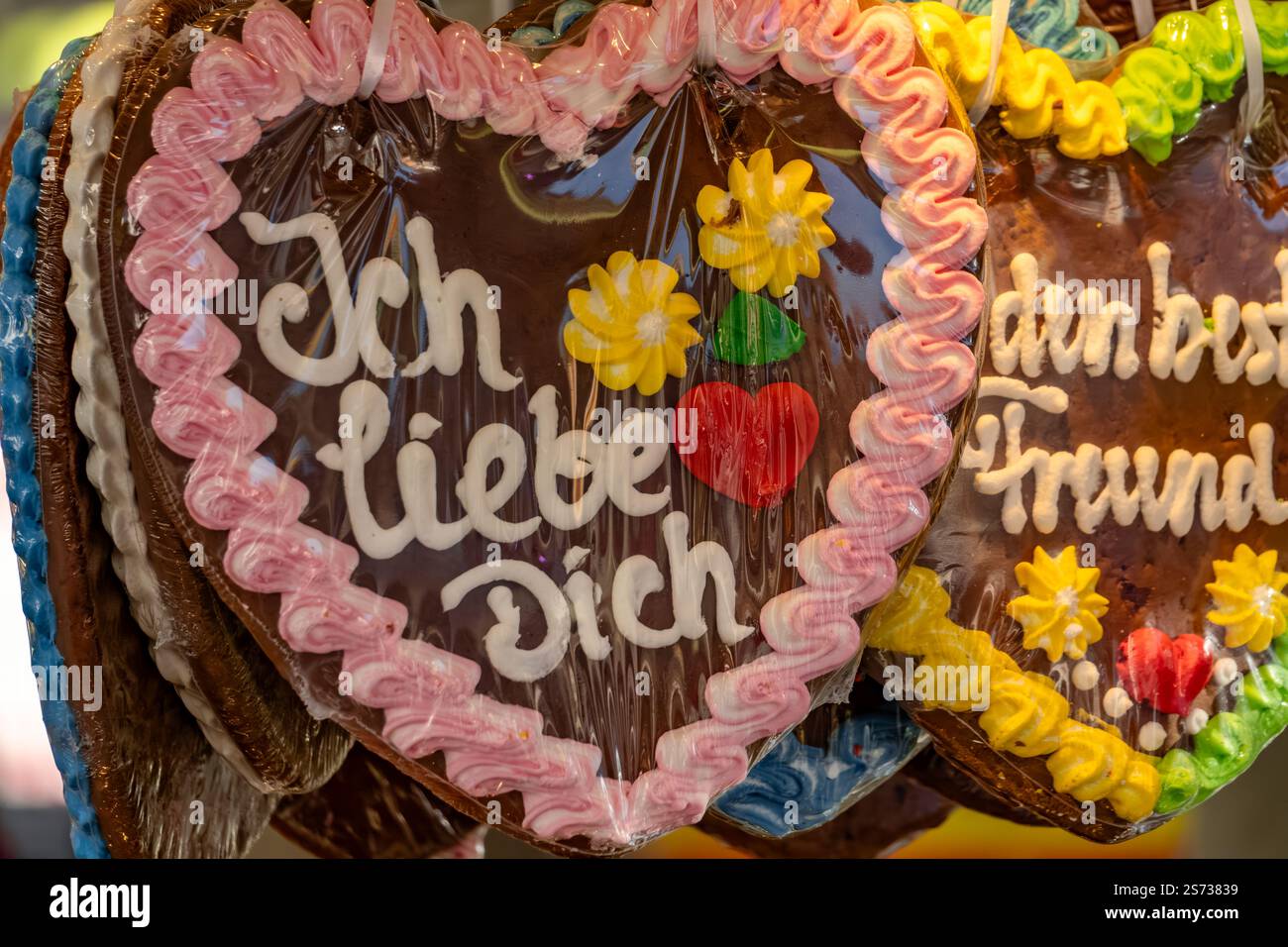 Eine Ausstellung herzförmiger Kekse mit der Aufschrift „Ich Liebe dich“. Die Kekse sind mit Zuckerguss dekoriert und hängen an einer Straße Stockfoto