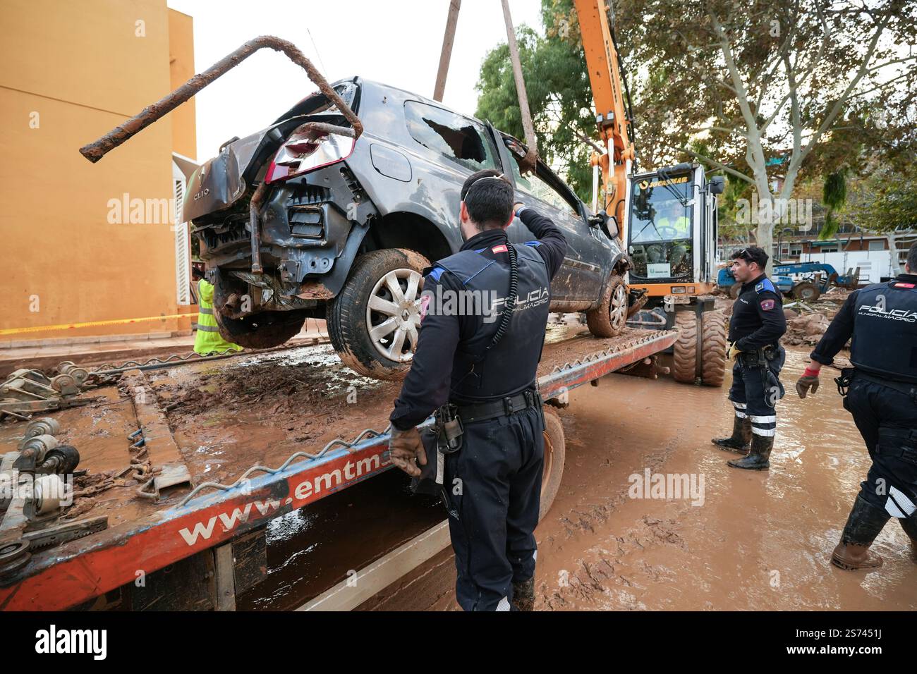 Nationales Polizeikorps (Spanien) während der Säuberungsarbeiten nach DANA-Überschwemmung, Schleppkran LKW laden beschädigtes Auto. Alfafar, Spanien. Stockfoto