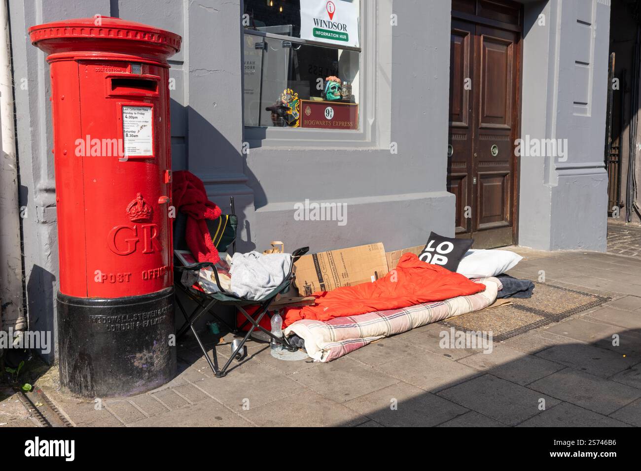 Windsor Vereinigtes Königreich - 12. August 2024; Bedding of Obdacheless auf dem Stadtfußweg neben der hellroten britischen Post Box. Stockfoto