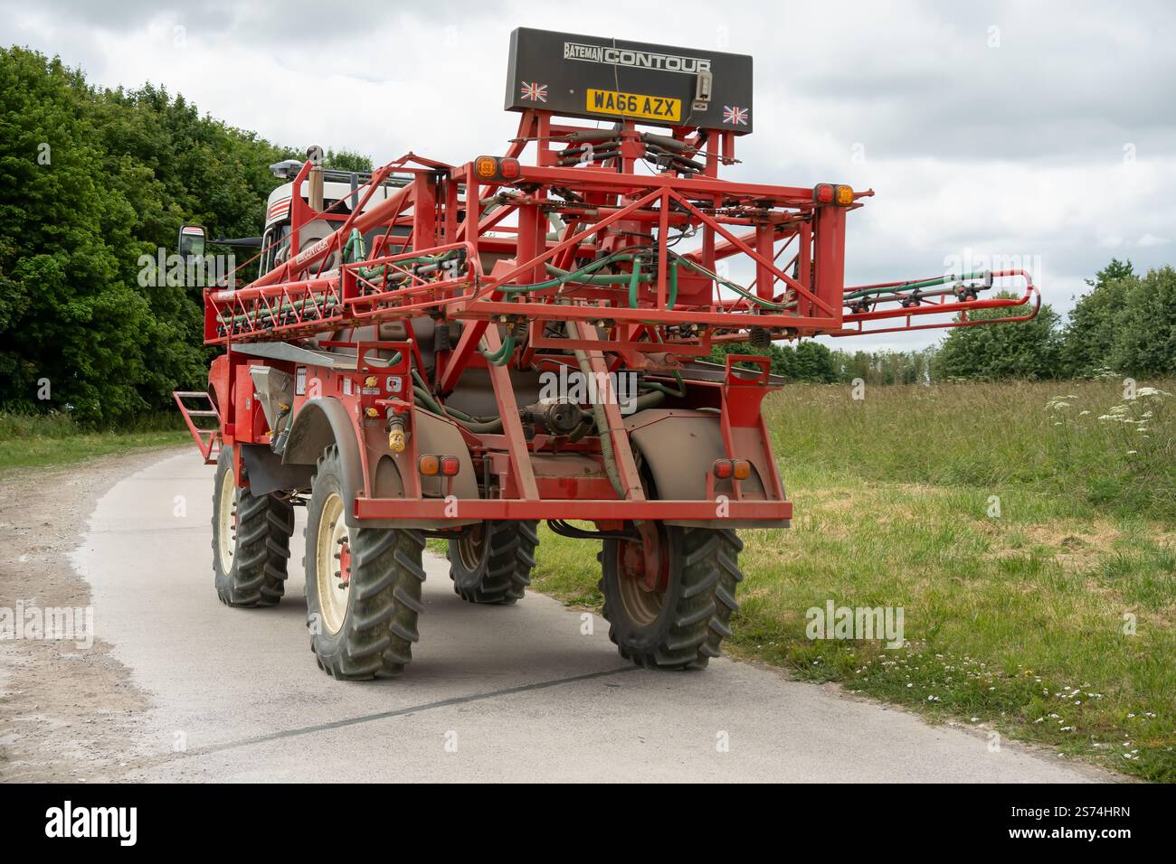 Eine große Feldspritze für Rotwein in Aktion auf einem Feld mit Jungweizen Stockfoto