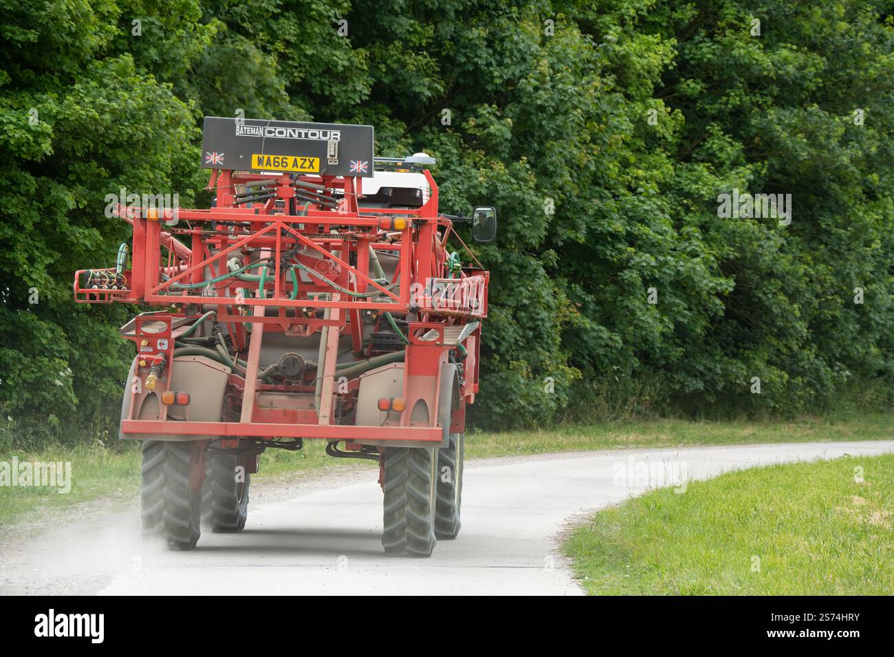 Eine große Feldspritze für Rotwein in Aktion auf einem Feld mit Jungweizen Stockfoto